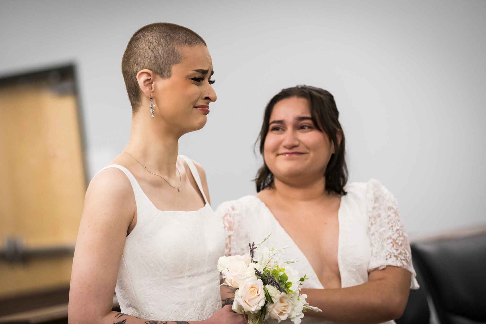 Two brides dressed in white during wedding ceremony at Bexar County Courthouse Precinct 3