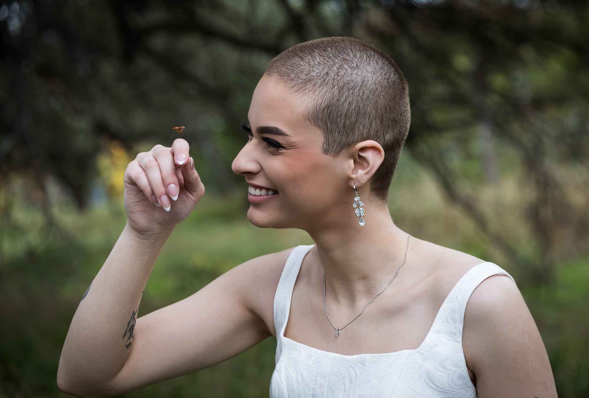 Walker Ranch Park wedding photo of bride with shaved head holding up hand as ladybug lands on finger