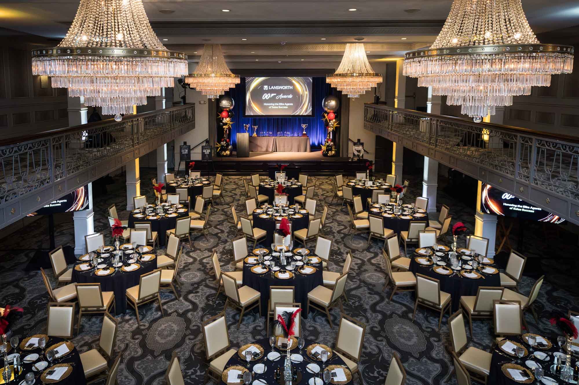 Wide view from the mezzanine level of the Anacacho Ballroom set for dinner under glass chandeliers for an article on a St. Anthony Hotel corporate event