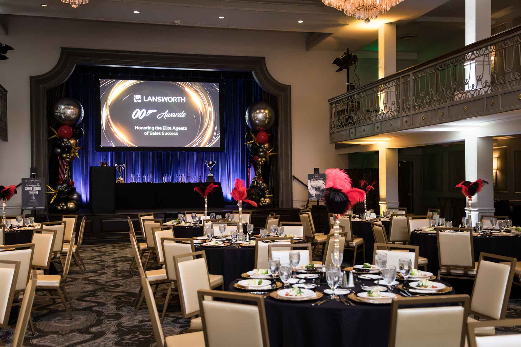 Anacacho Ballroom set for dinner stage showing balloon sculptures, screen, and table with awards for an article on a St. Anthony Hotel corporate event