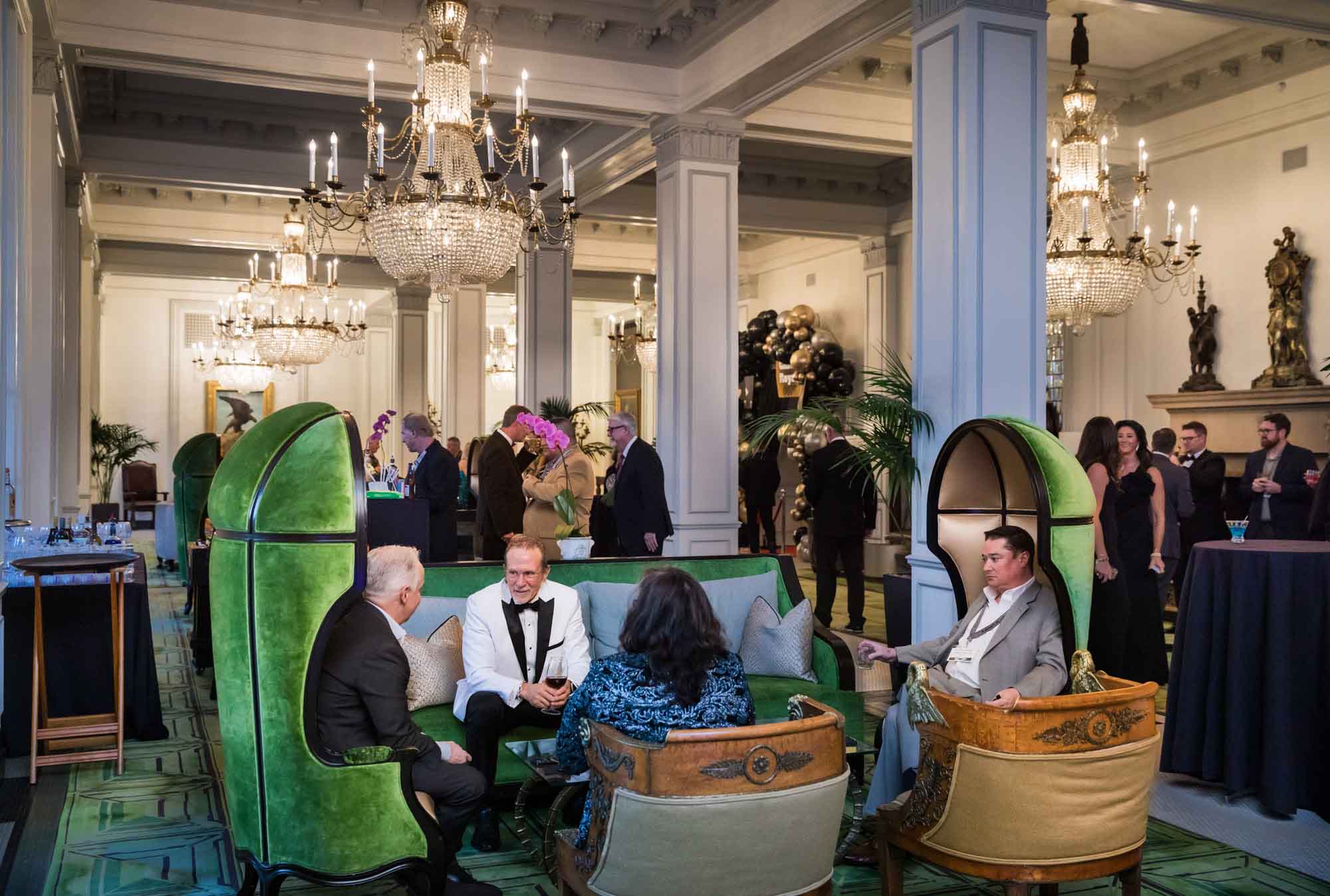 Guests sitting and standing in the Peacock Alley for an article on a St. Anthony Hotel corporate event