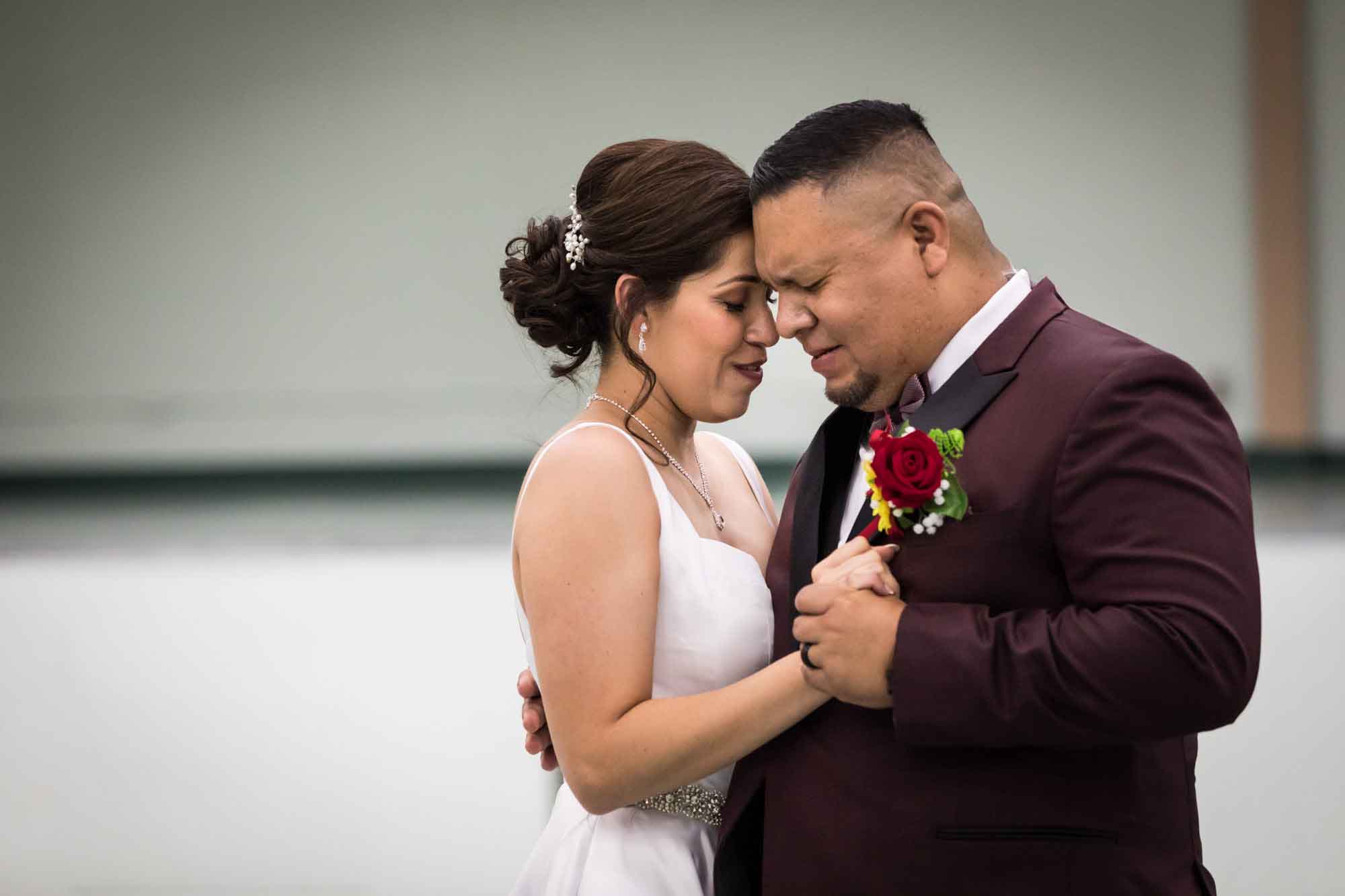Bride and groom dancing close and touching foreheads for an article on top 20 things to ask your wedding photographer