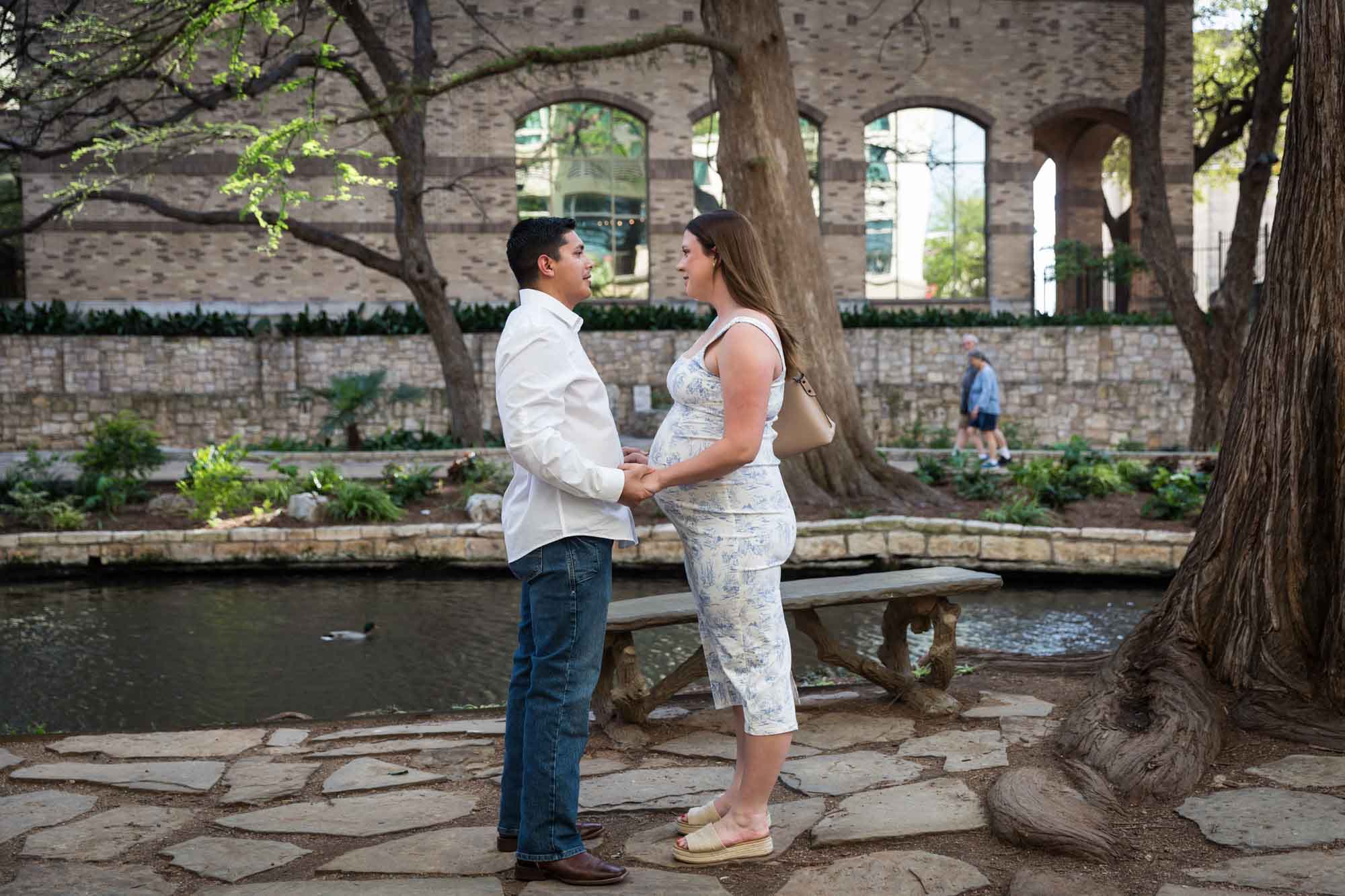 Man speaking to pregnant fiancee during Marriage Island proposal for an article on the best place to propose on the River Walk