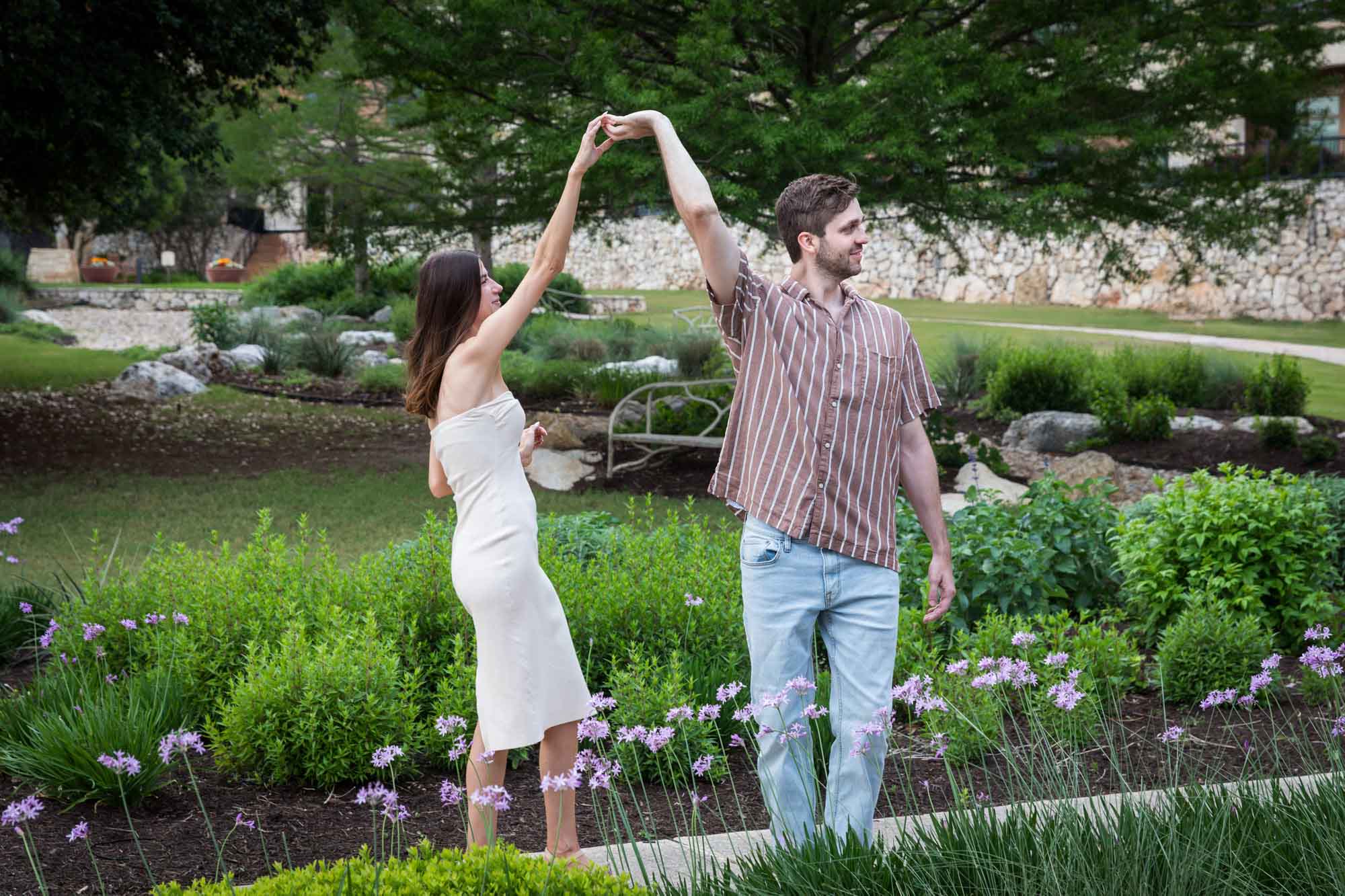 JW Marriott San Antonio Hill Country Resort engagement photo of couple dancing together in front of garden