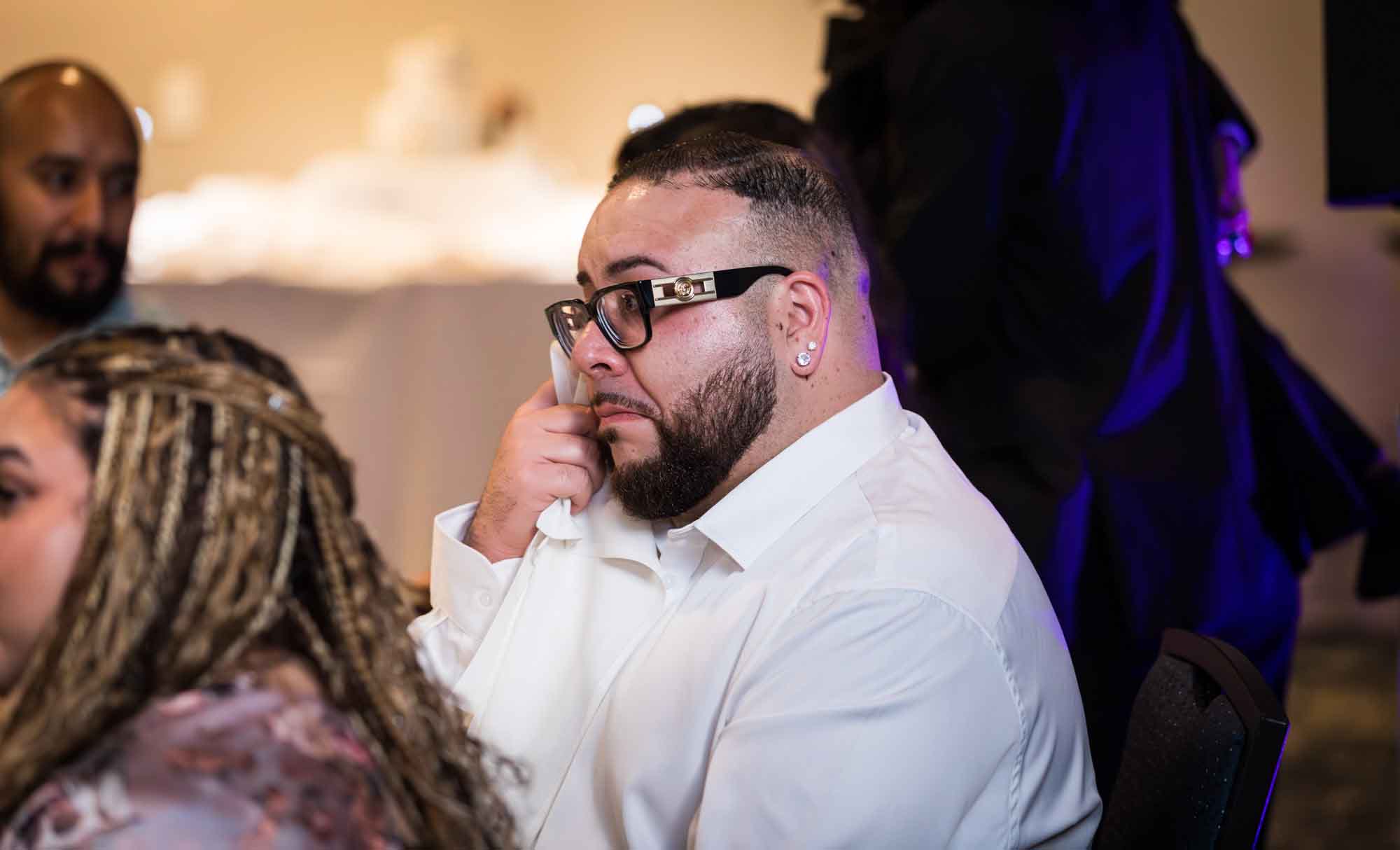 Centre Club wedding reception photo of man wearing glasses wiping away tear