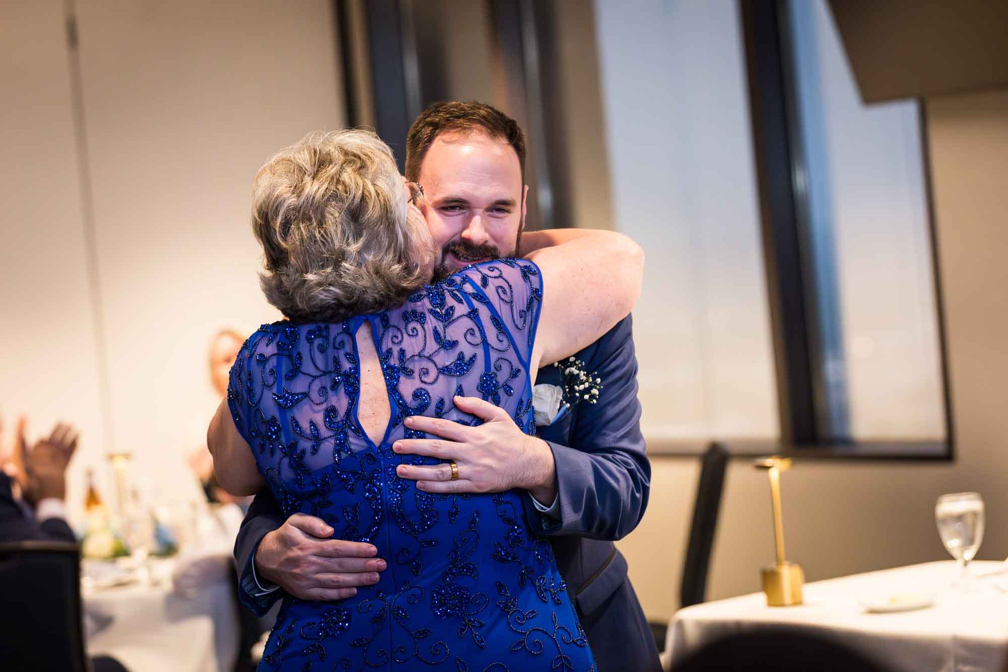 Centre Club wedding reception photo of groom hugging mother in blue dress