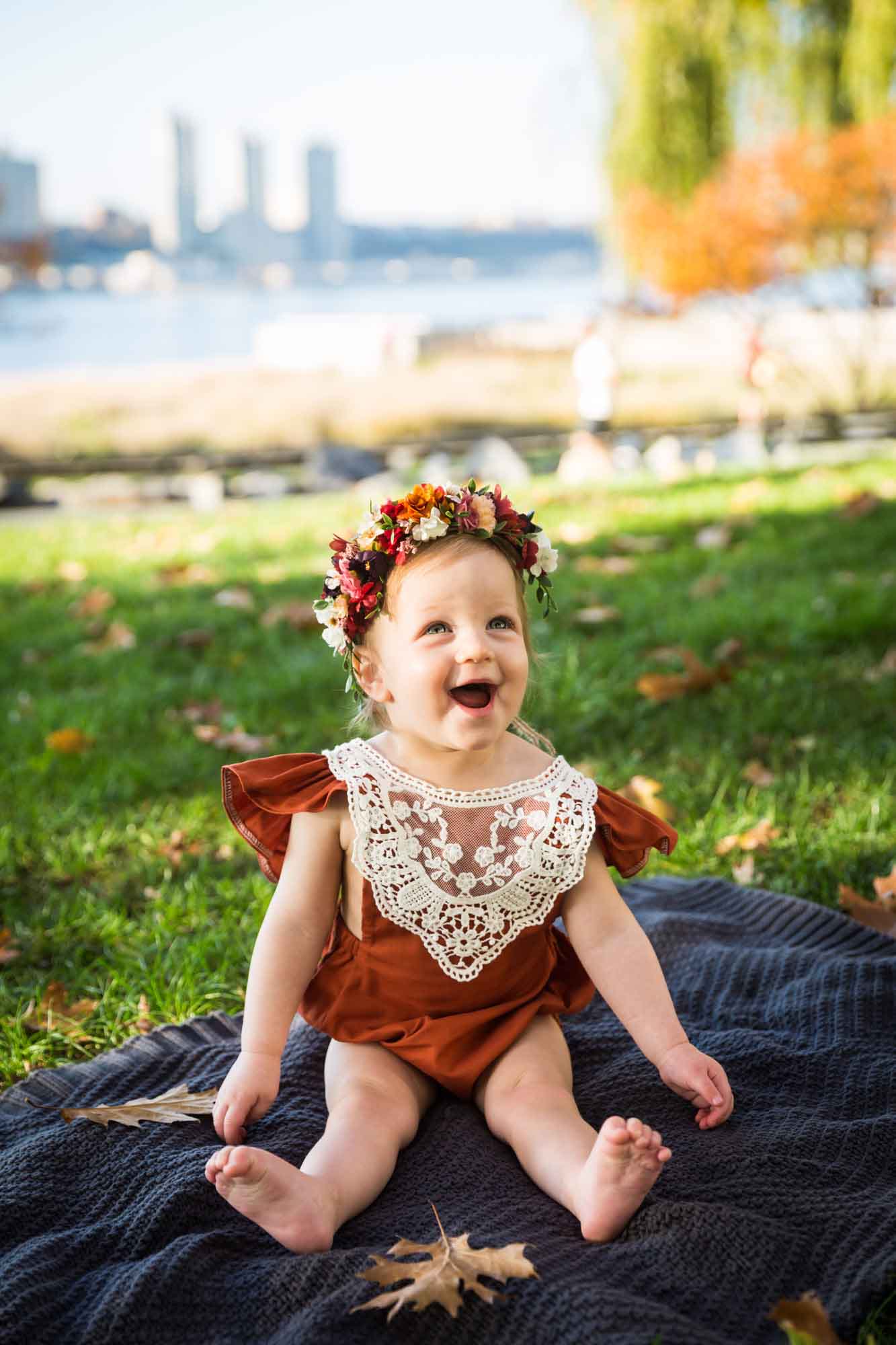 Little girl laughing on a blanket for an article NYC golden hour portrait tips