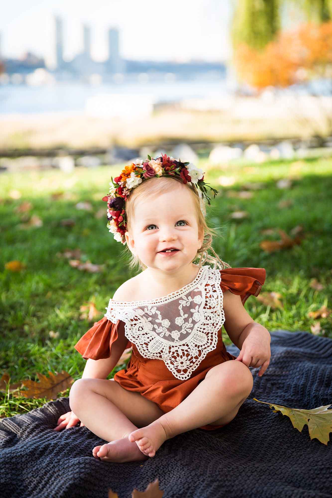 Little girl smiling on a blanket in Riverside Park