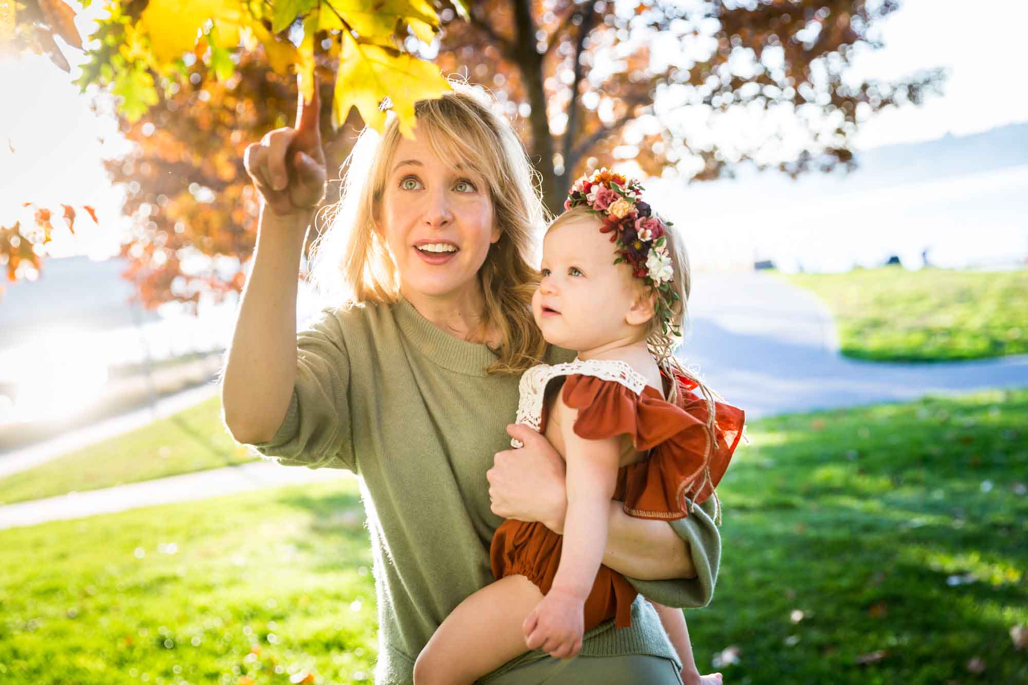 Mother showing leaf to baby girl for an article NYC golden hour portrait tips