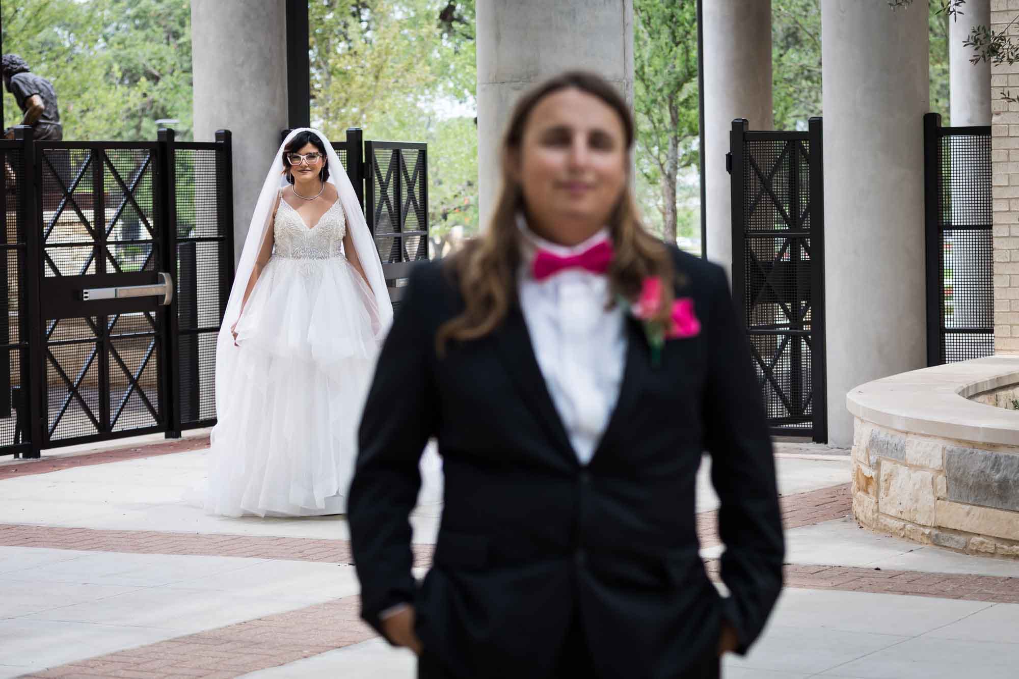 Cornerstone Church wedding photos of view over groom's shoulder of bride wearing long veil during first look