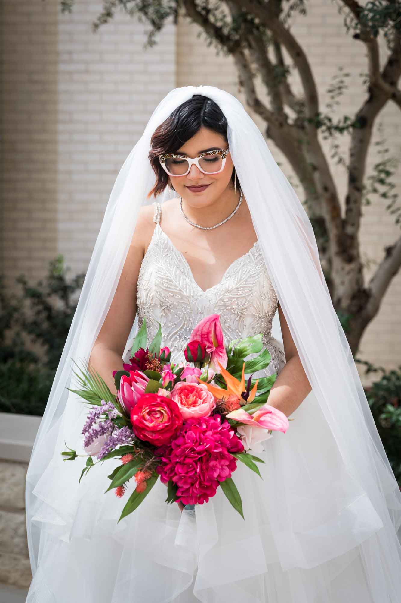 Cornerstone Church wedding photos of bride wearing sleeveless dress, long veil, and holding large flower bouquet