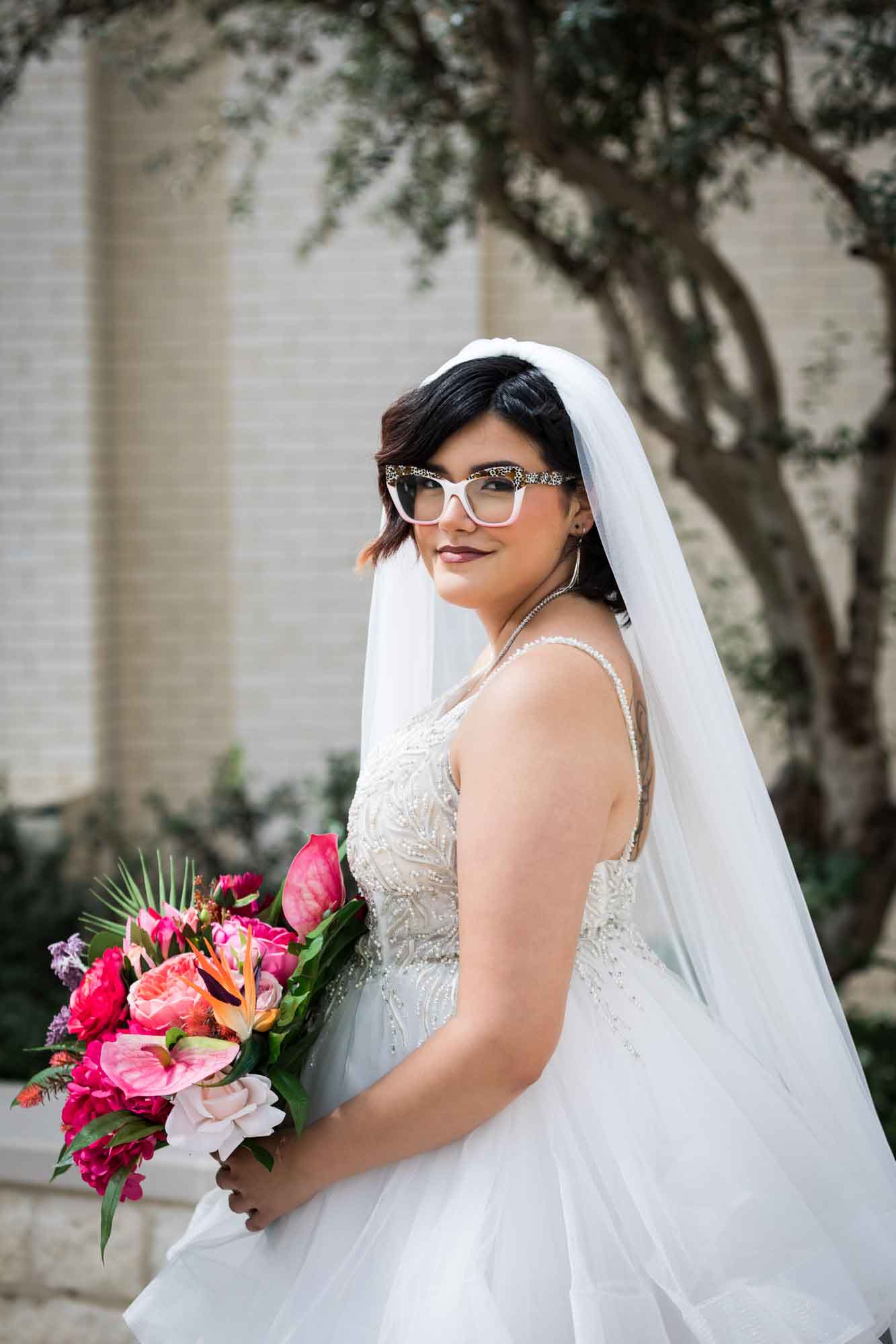 Cornerstone Church wedding photos of bride wearing sleeveless white dress, long veil, and holidng large flower bouquet