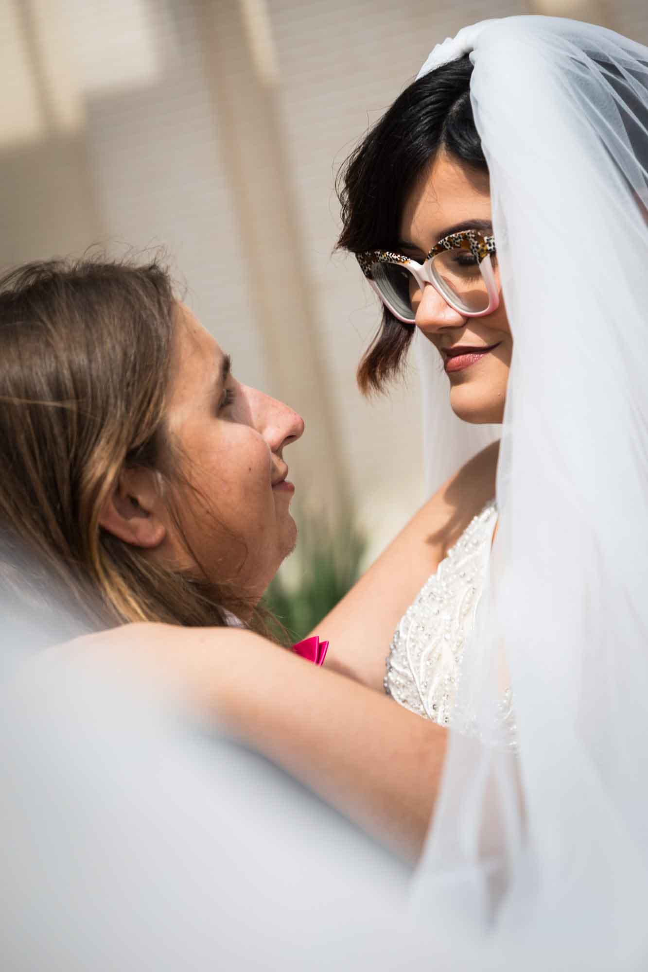 Cornerstone Church wedding photos of bride and groom standing close while enveloped in bride's white veil