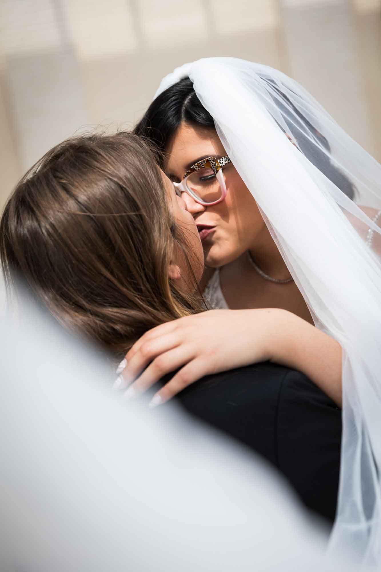 Cornerstone Church wedding photos of bride and groom kissing while enveloped in bride's white veil