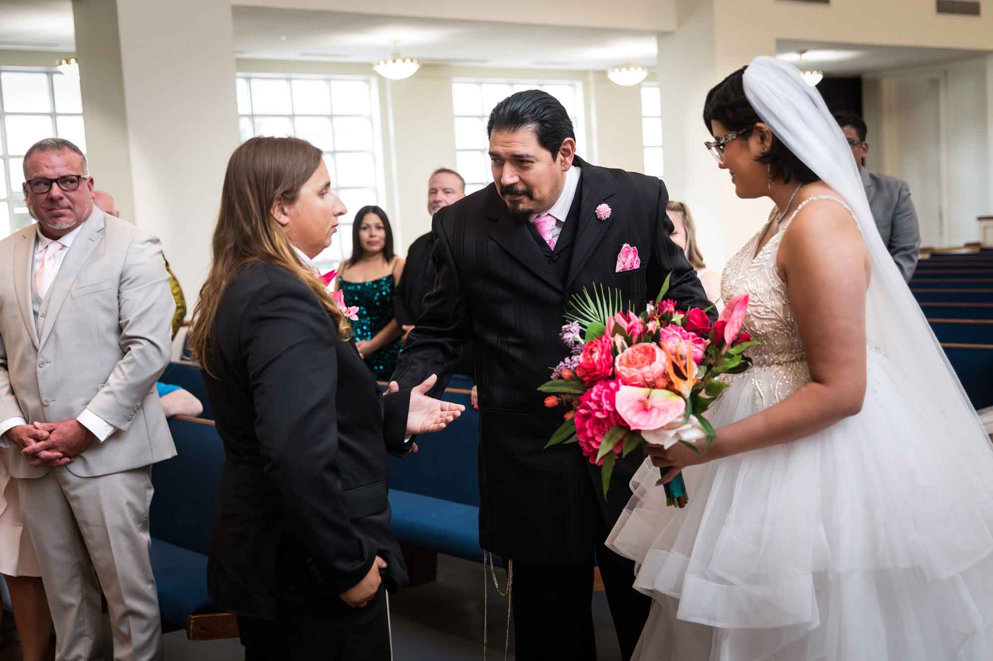 Cornerstone Church wedding photos of bride's father giving bride to groom in front of guests during ceremony