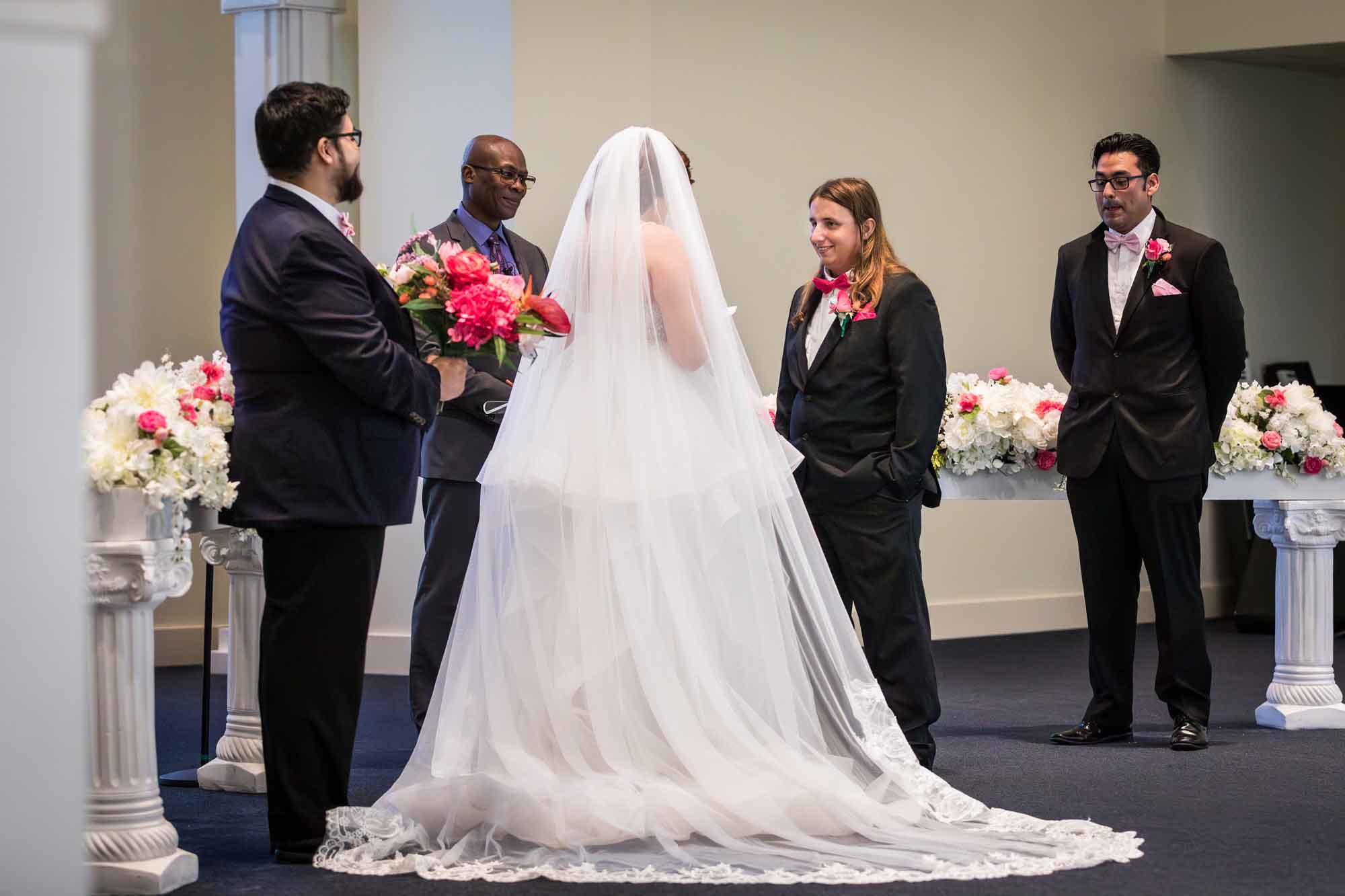 Cornerstone Church wedding photos of bride and groom saying vows in front of officiant and two groomsmen during ceremony