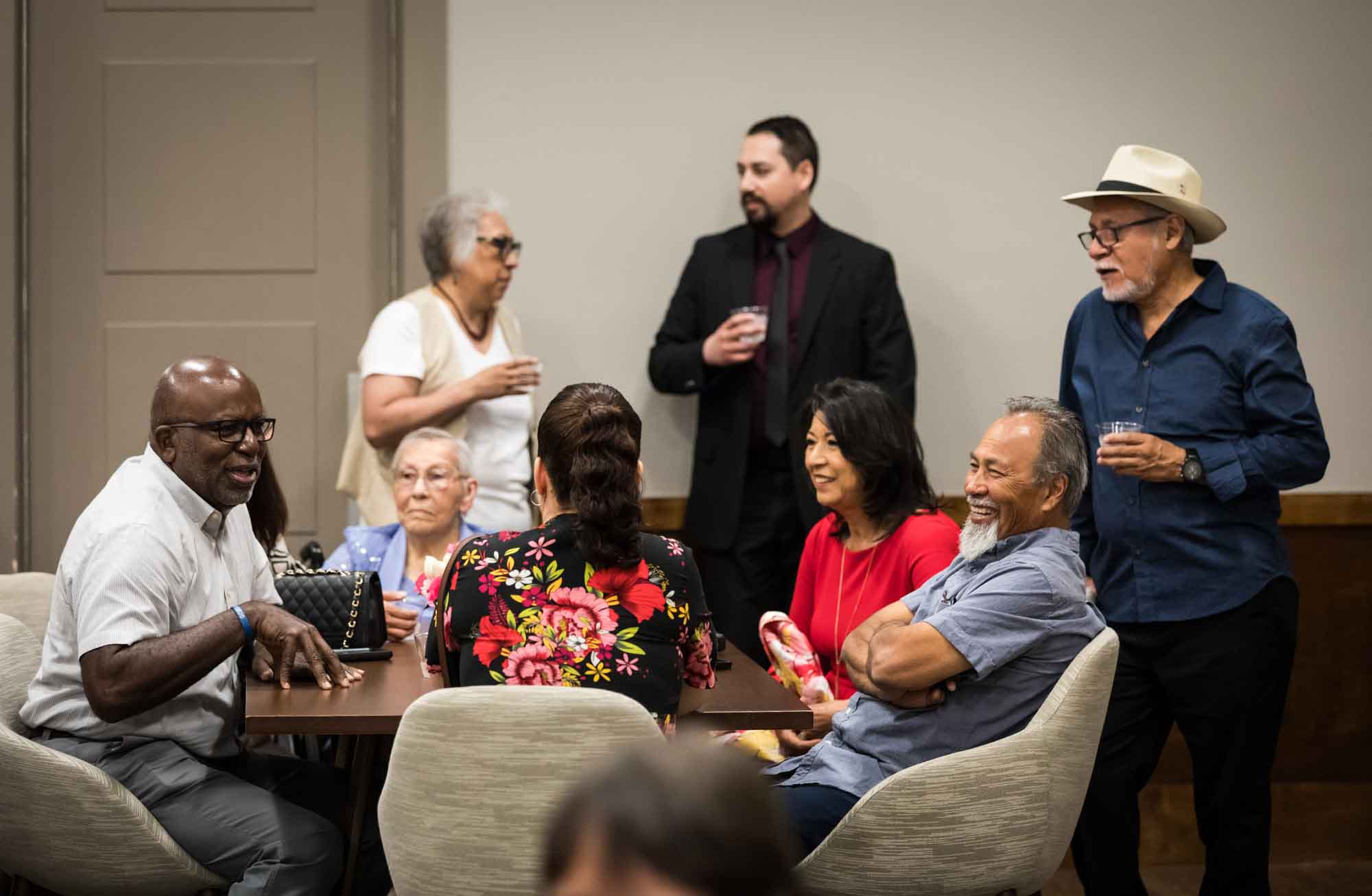 Guests laughing and enjoying themselves around a table during a wedding reception at Cornerstone Church