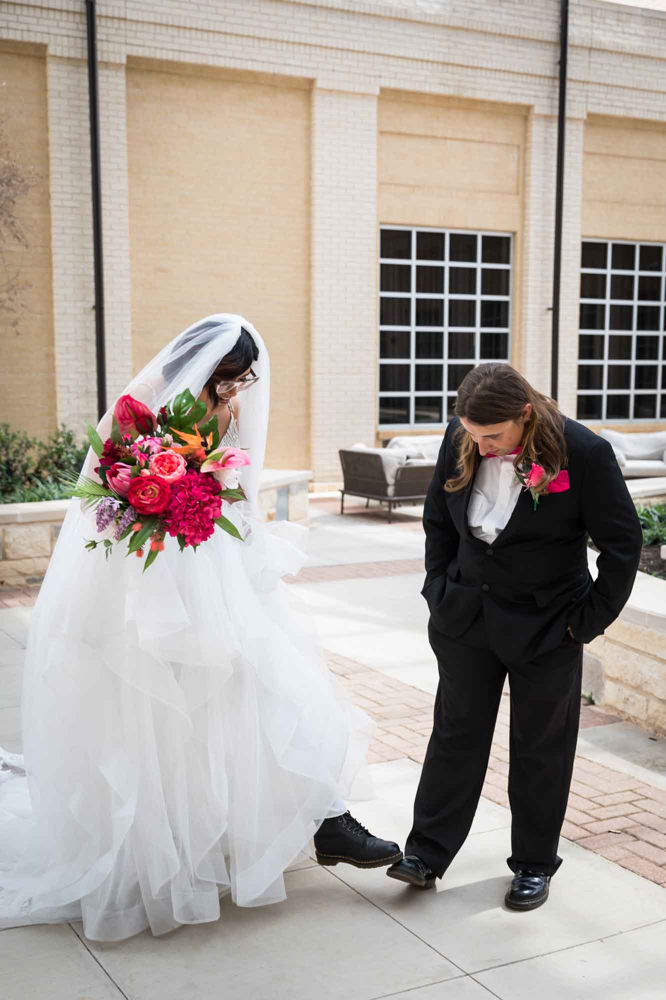 Cornerstone Church wedding photos of bride and groom comparing shoes in courtyard