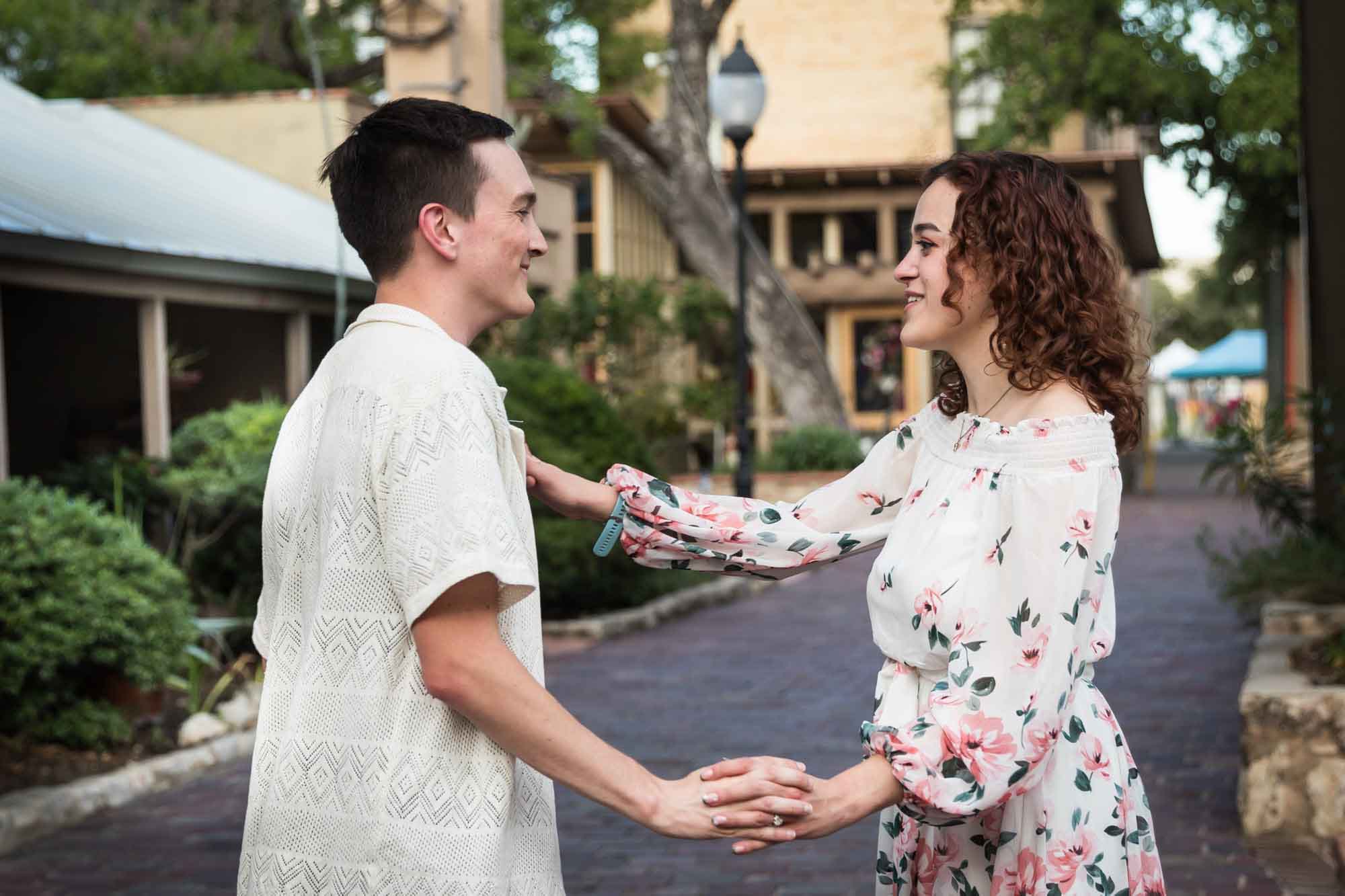 Couple dancing on cobblestone streets at La Villita during downtown San Antonio engagement portrait