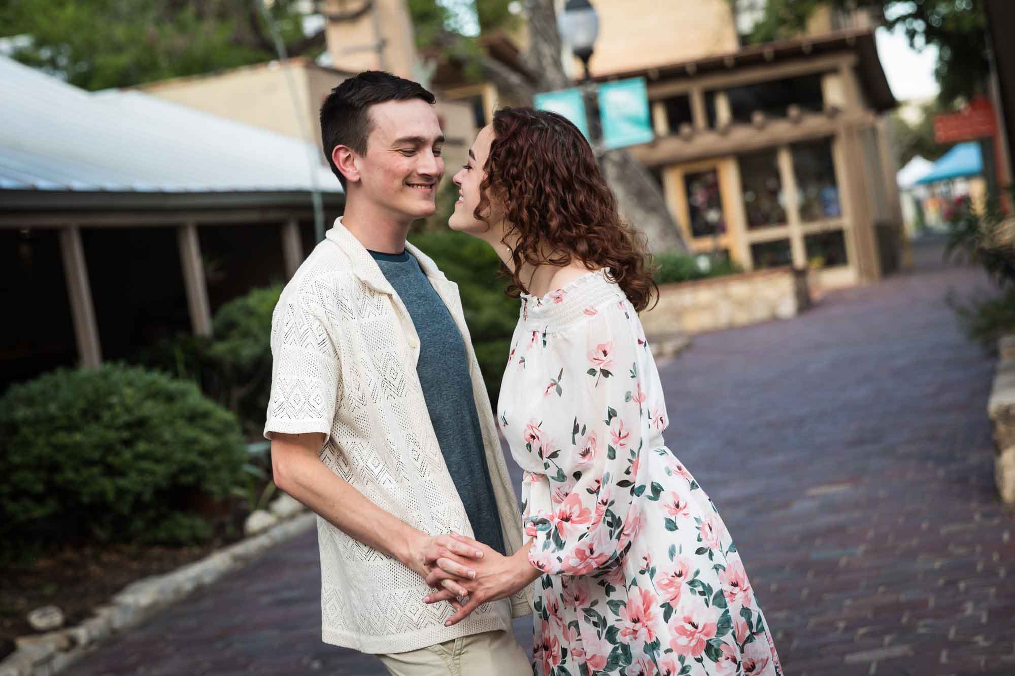 Couple dancing on cobblestone streets at La Villita during downtown San Antonio engagement portrait