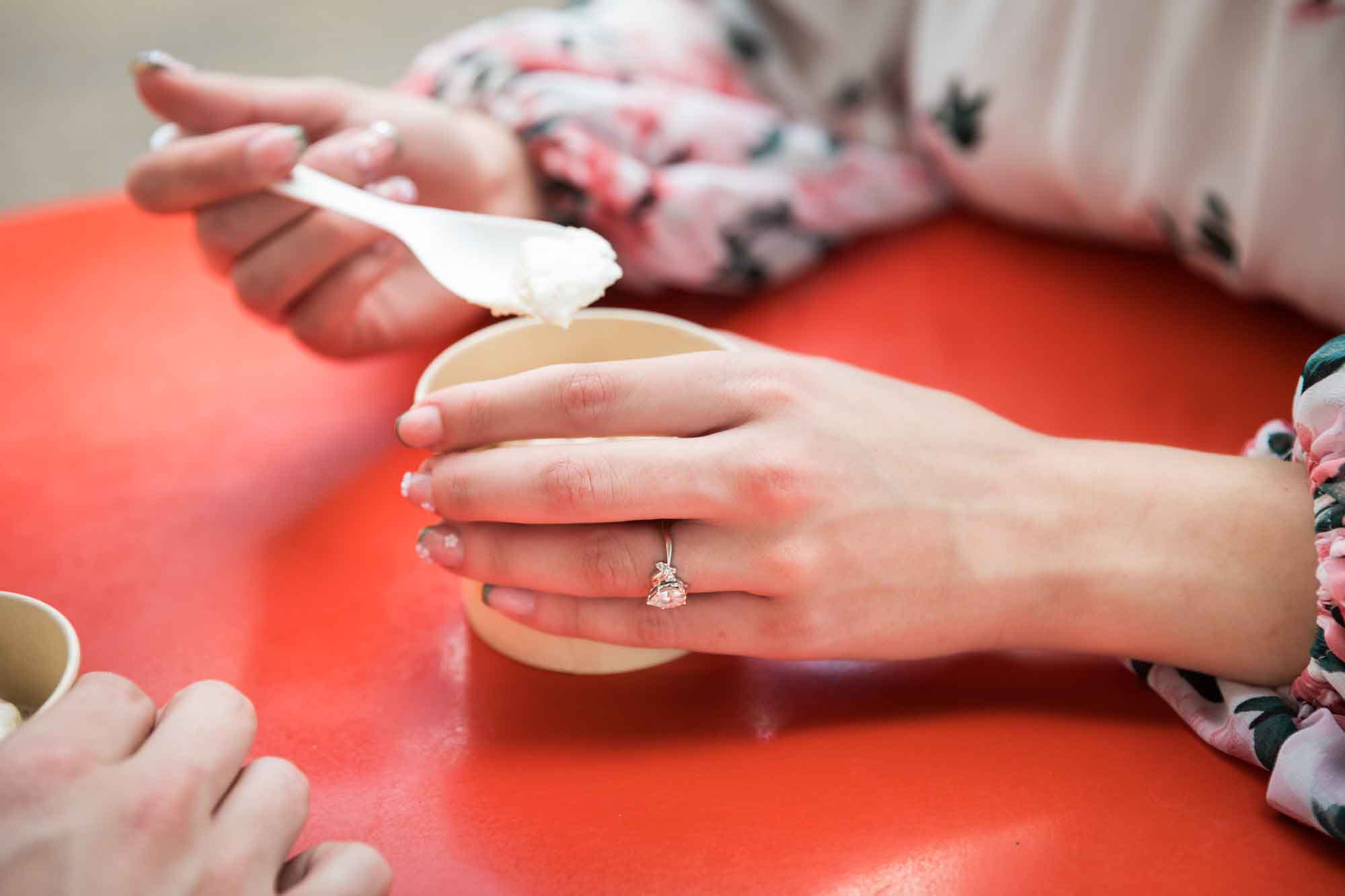 Close up of woman's hand holding ice cream cup showing engagement ring during a downtown San Antonio engagement portrait session