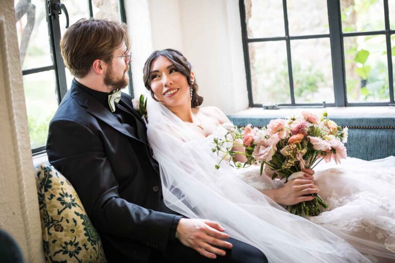 The Veranda wedding photos of bride and groom sitting together in corner in front of window