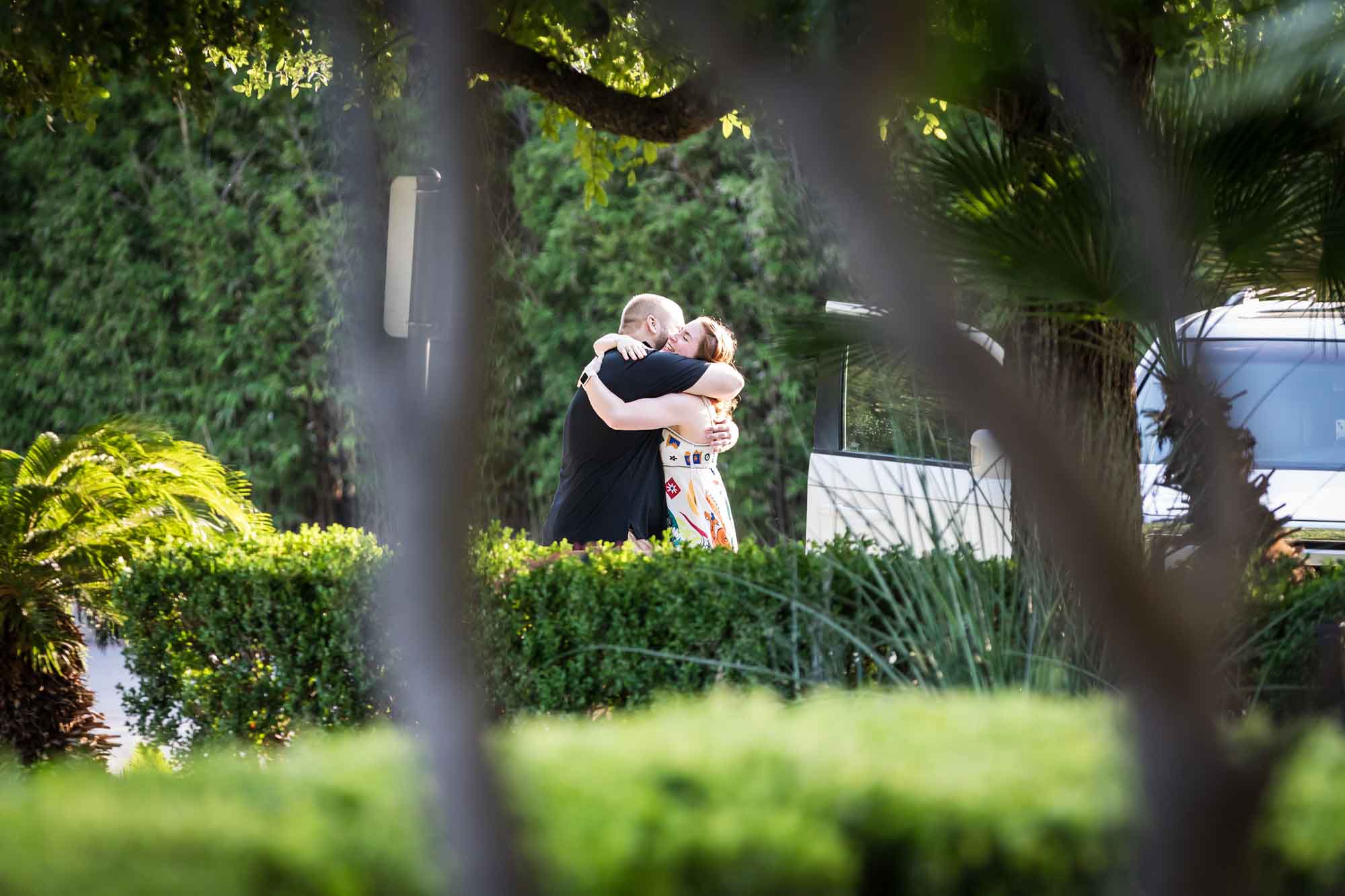 Couple hugging in parking lot during a Landa Library surprise proposal