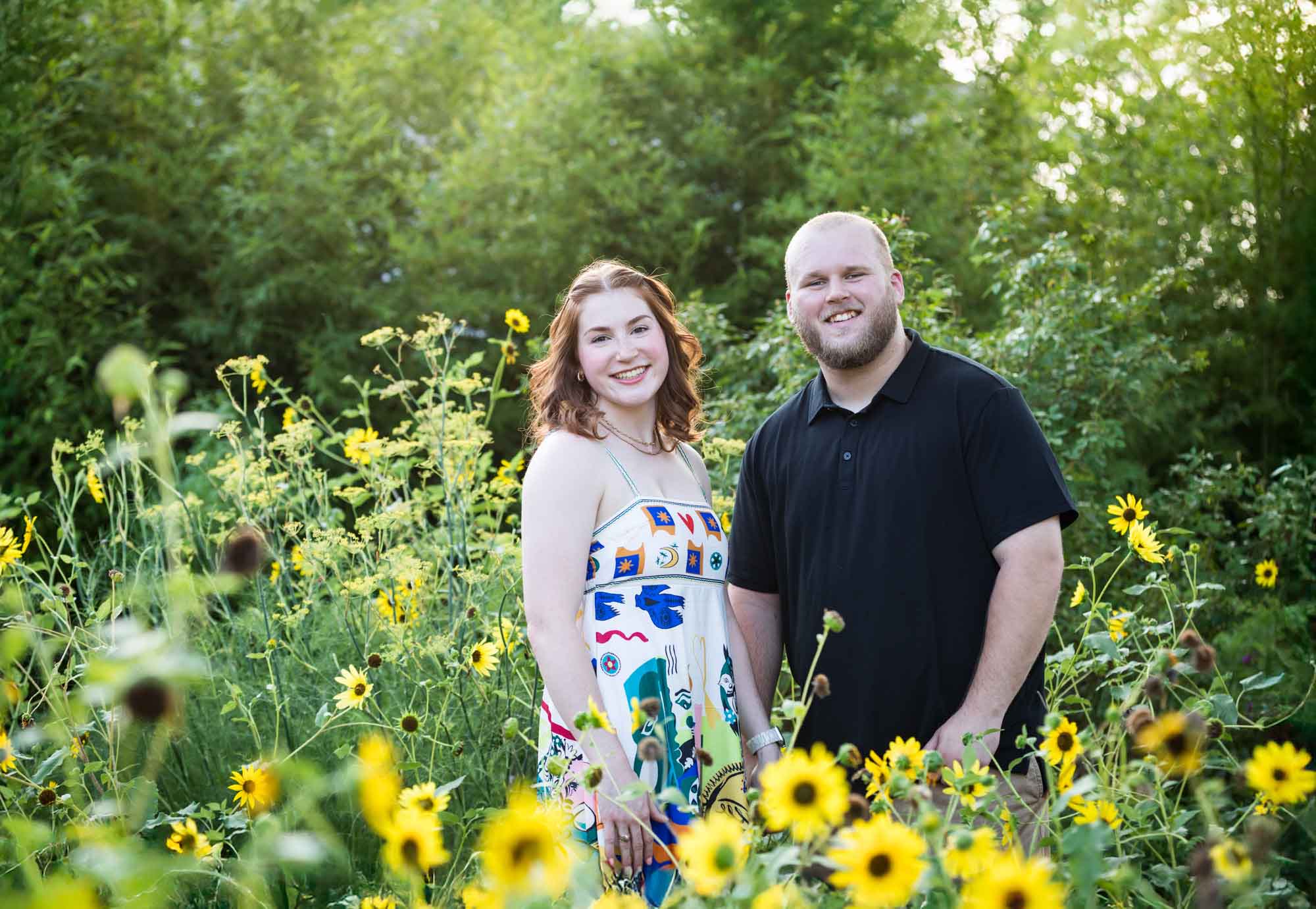 Couple smiling in flower garden during a Landa Library engagement portrait