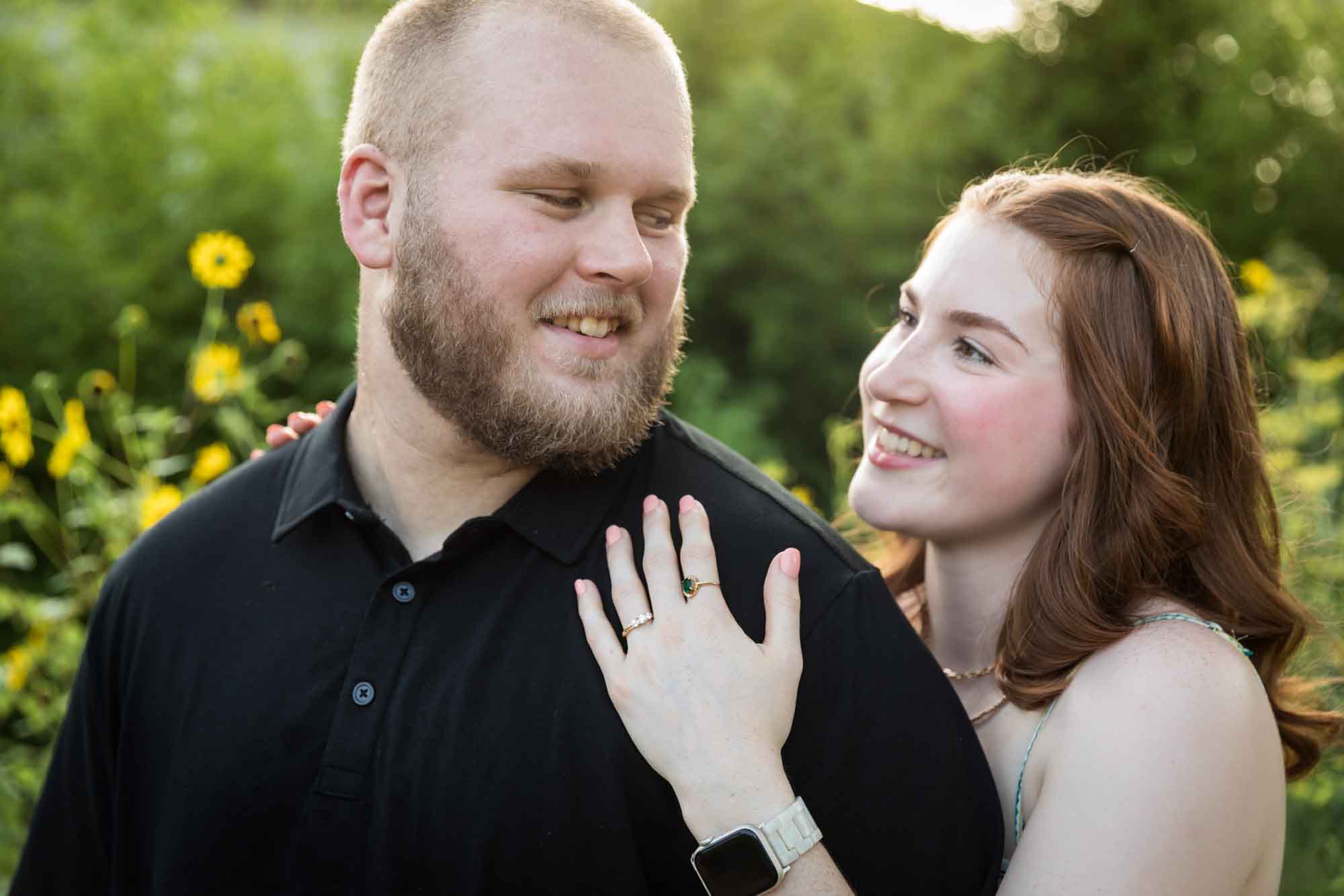 Couple hugging in flower garden of sunflowers during a Landa Library engagement portrait