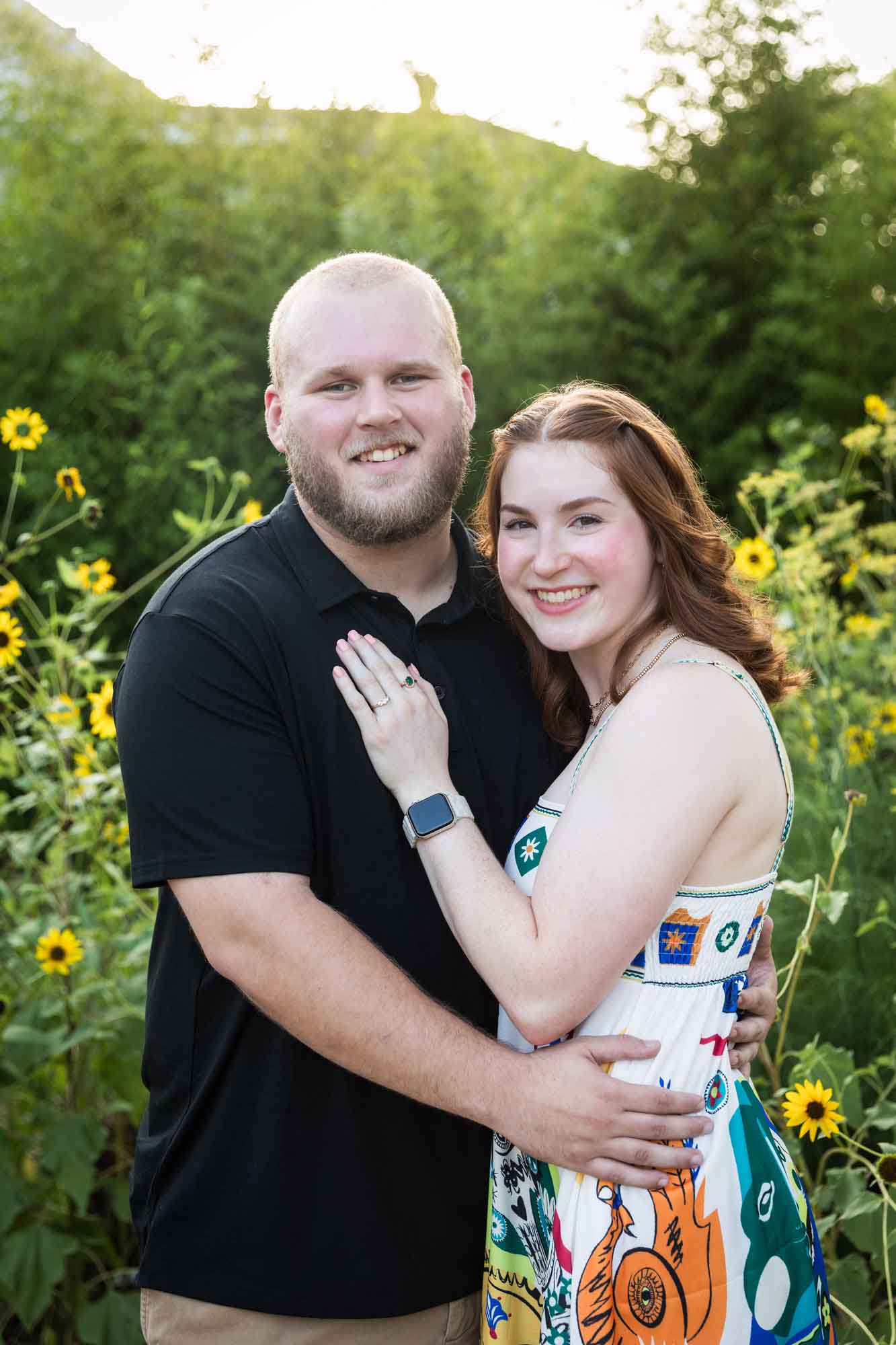 Couple hugging in flower garden of sunflowers during a Landa Library engagement portrait