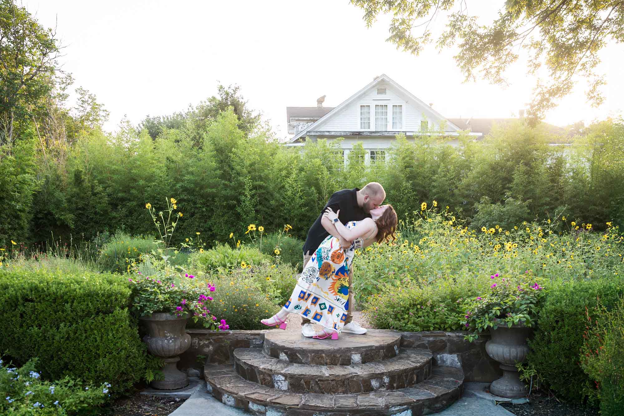 Couple dancing on brick steps in flower garden after a Landa Library proposal