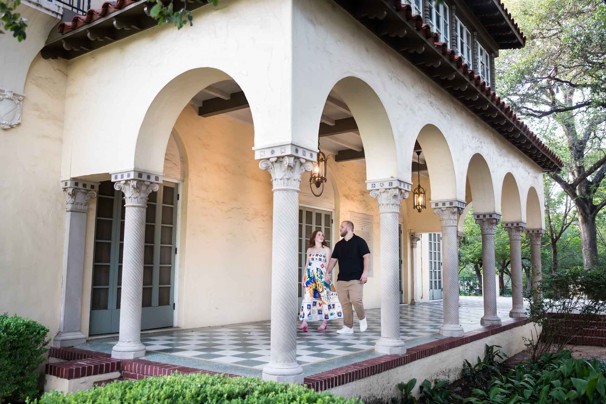 Couple walking along colonnade for an article on how to propose at the Landa Library