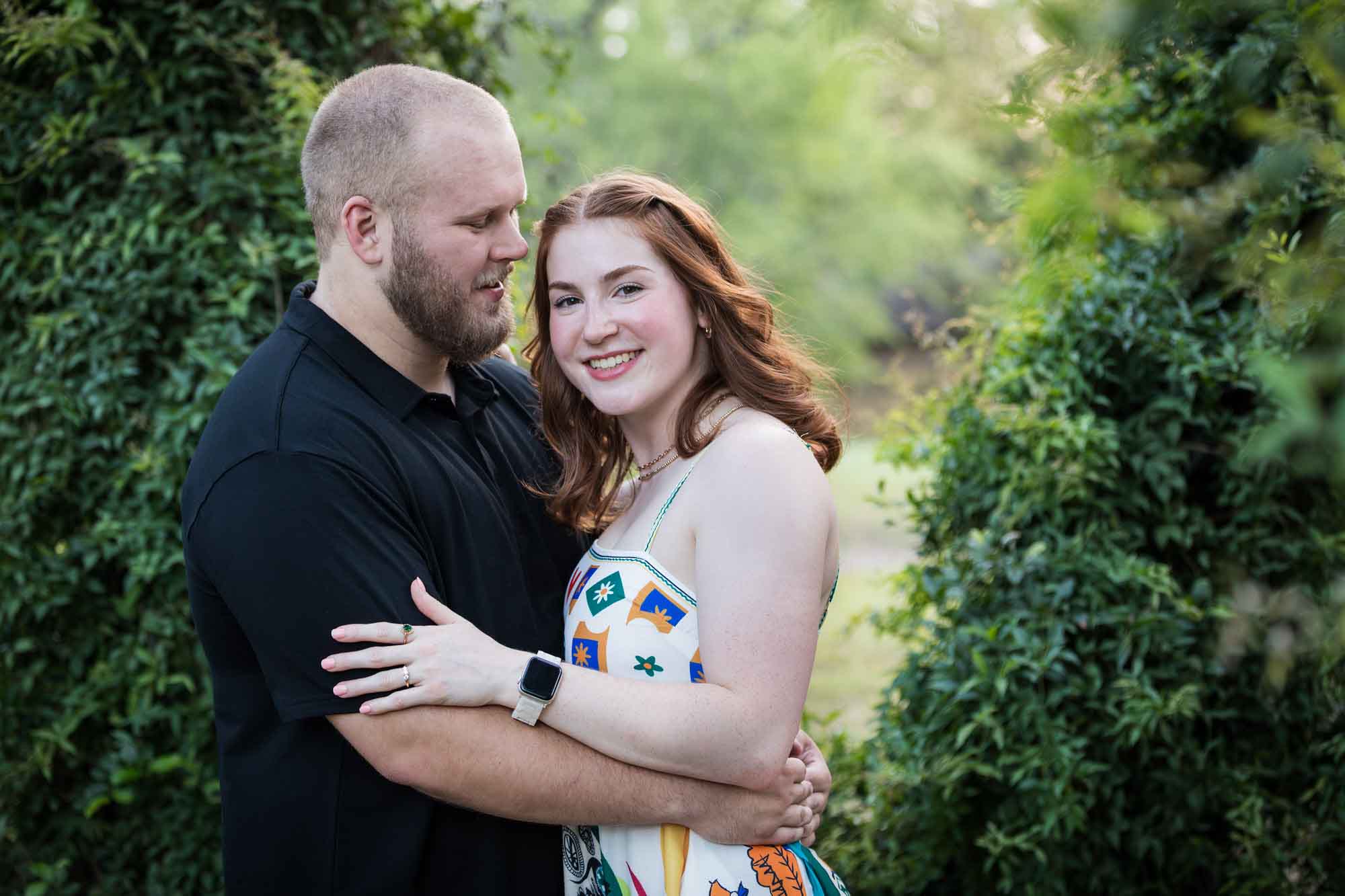 Couple dancing in front of vine-covered trees during a Landa Library engagement portrait