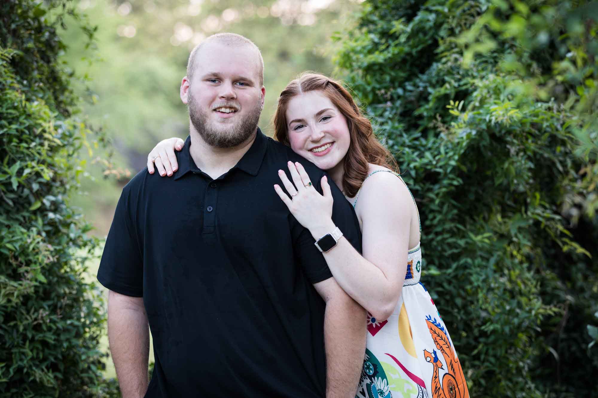 Couple dancing in front of vine-covered trees during a Landa Library engagement portrait