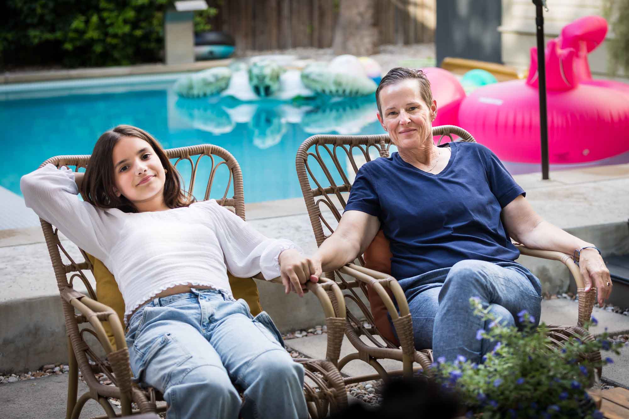Mother and teenage girl holding hands in front of pool relaxing during a King William family portrait