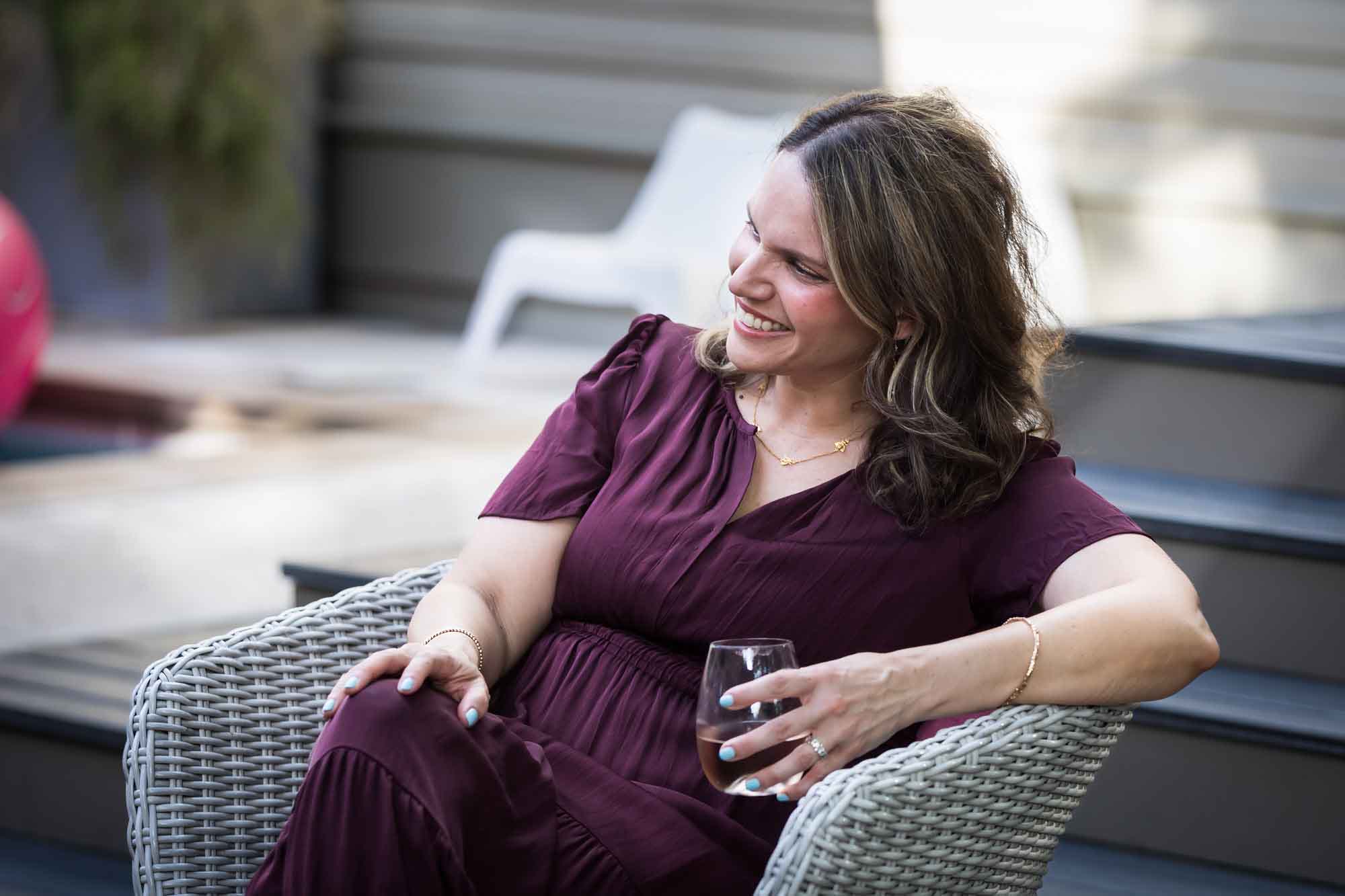 Woman wearing maroon dress holding wine glass relaxing during a King William family portrait