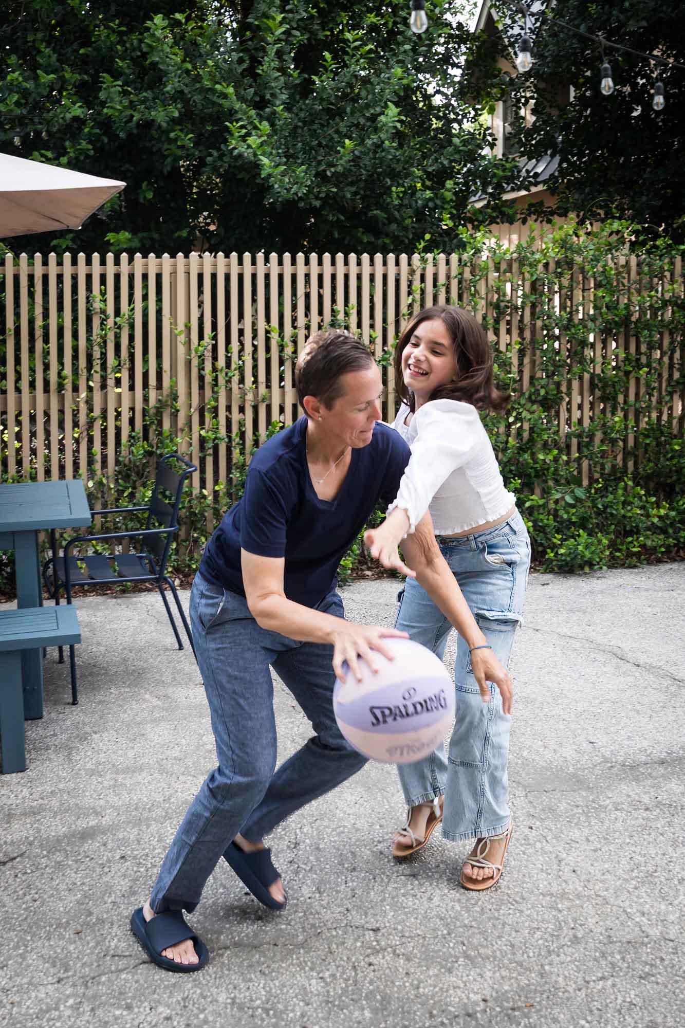 Mother and teenage daughter playing basketball in backyard during a King William family portrait