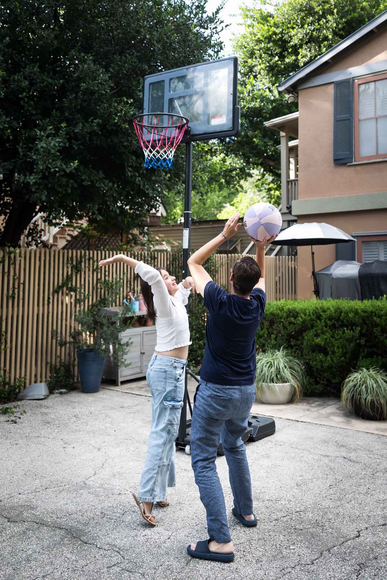 Mother and teenage daughter playing basketball in backyard during a King William family portrait