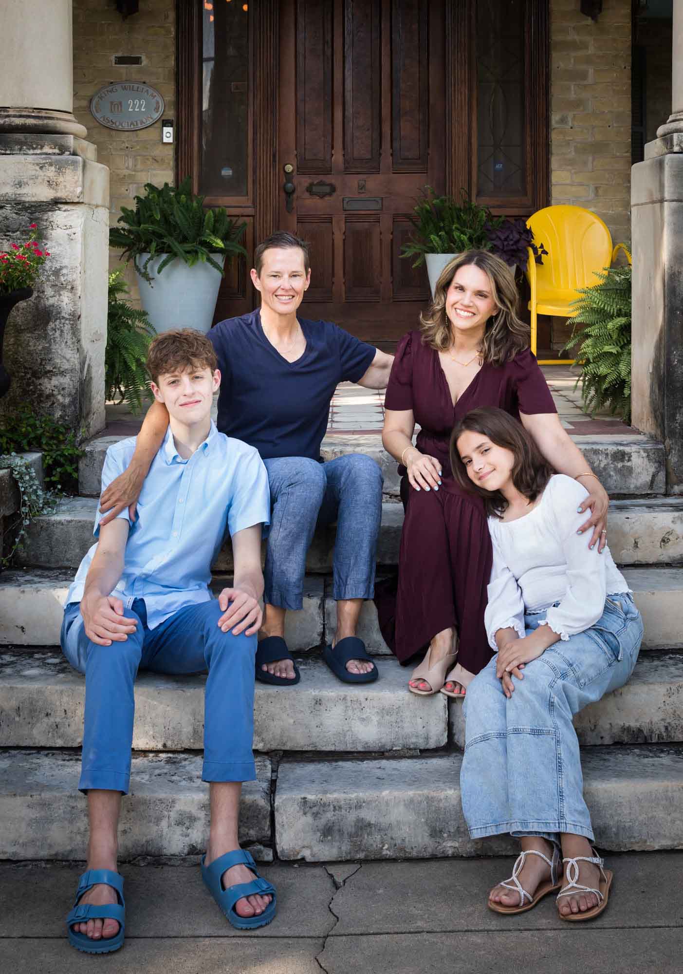 LGBTQ family of two women and two teenage children posed on steps of home during a King William family portrait