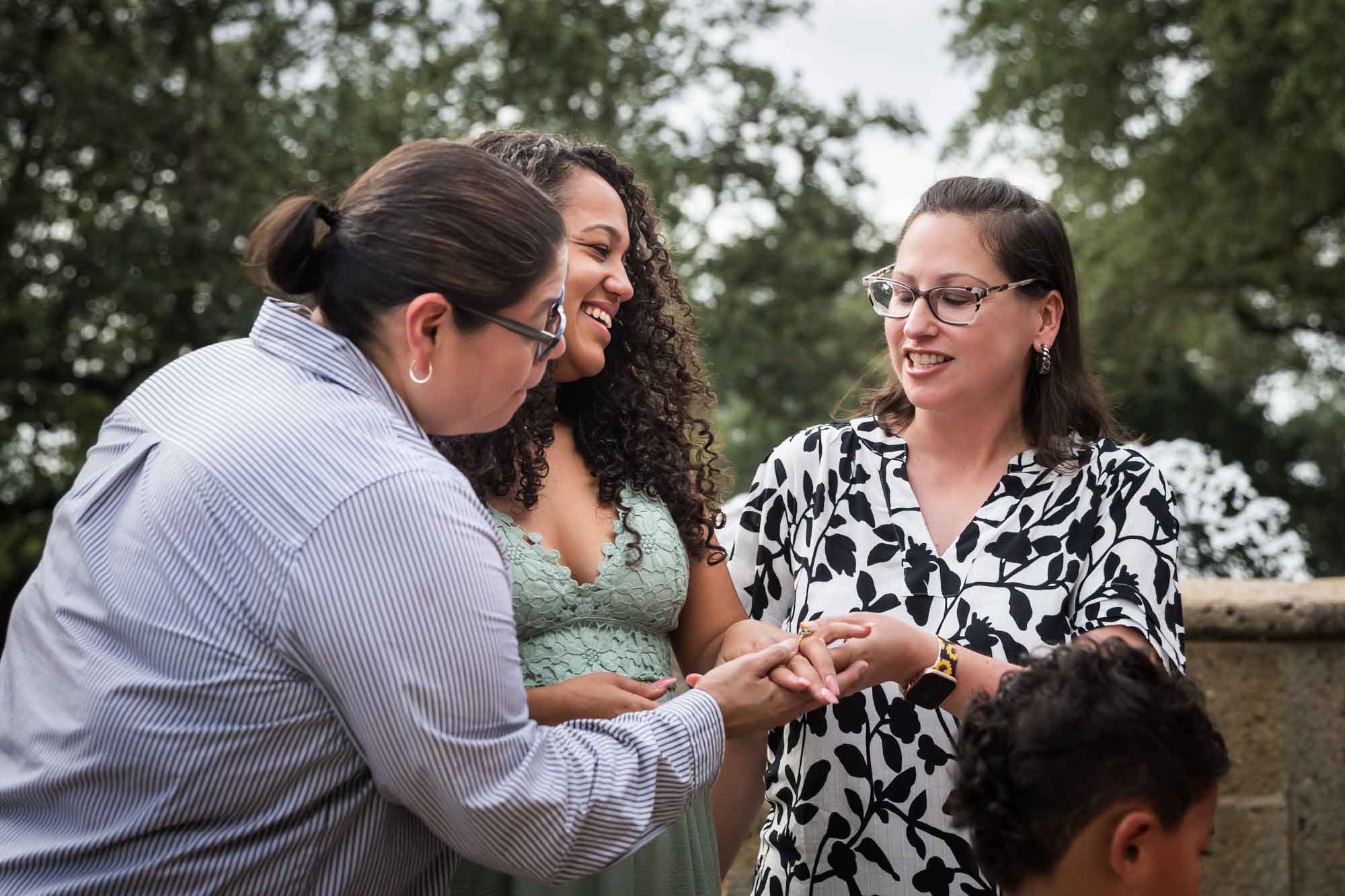 Two women looking at engagement ring on another woman's hand