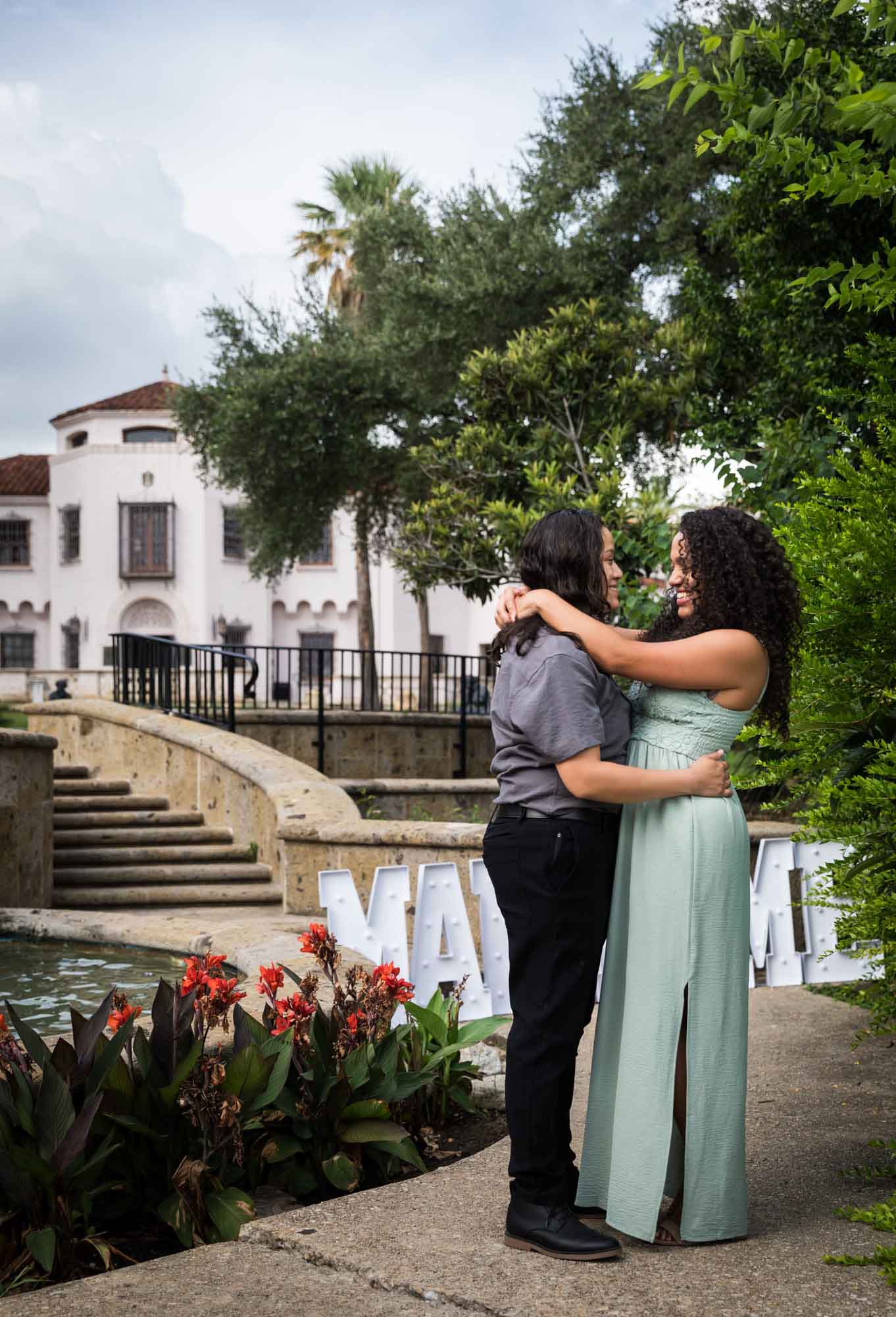 Two women hugging in front of McNay Art Museum mansion for an article about McNay Art Museum proposal tips