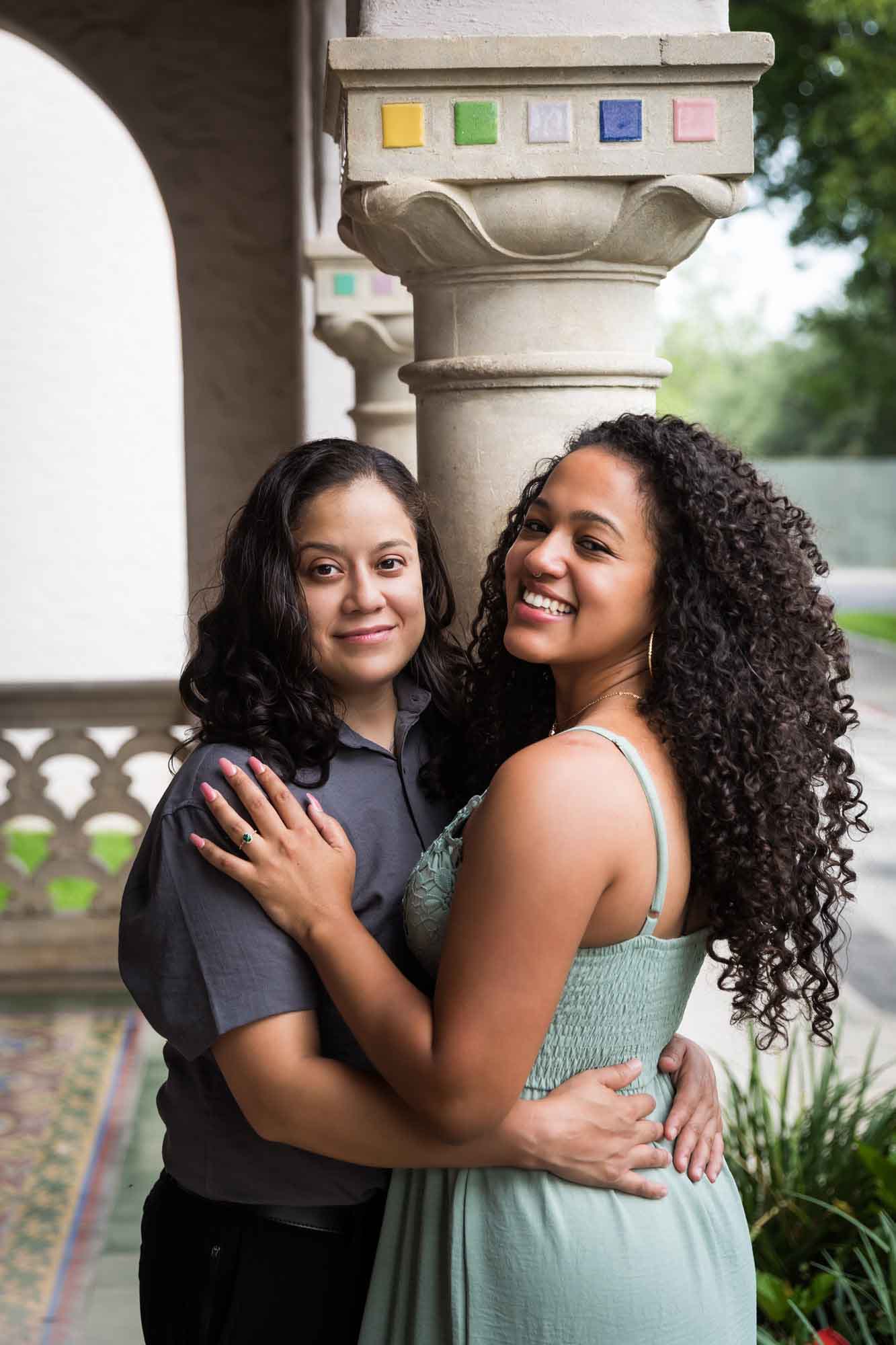 Two women hugging against multicolored mosaic column for an article about McNay Art Museum proposal tips