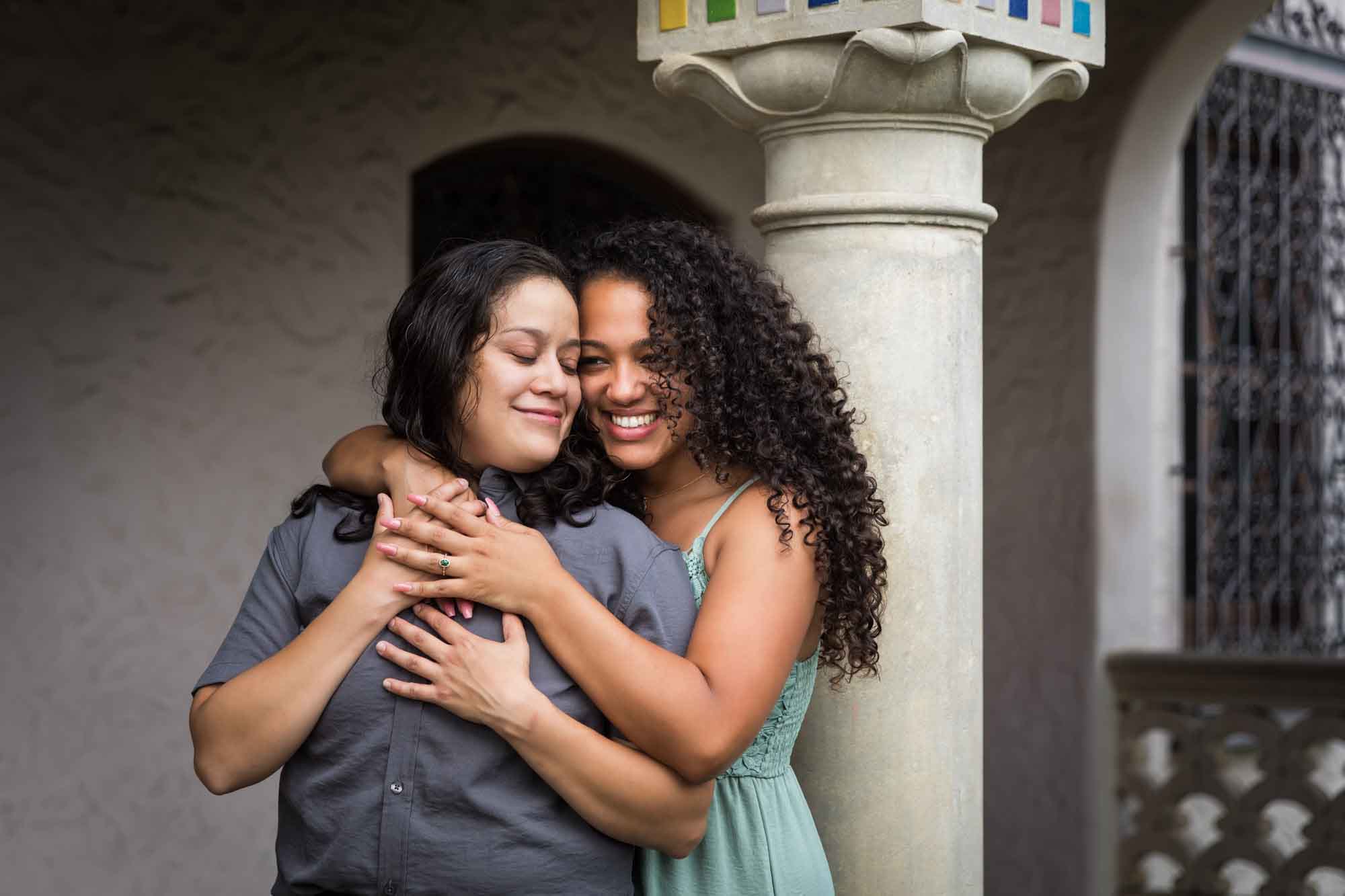 Two women hugging against multicolored mosaic column for an article about McNay Art Museum proposal tips