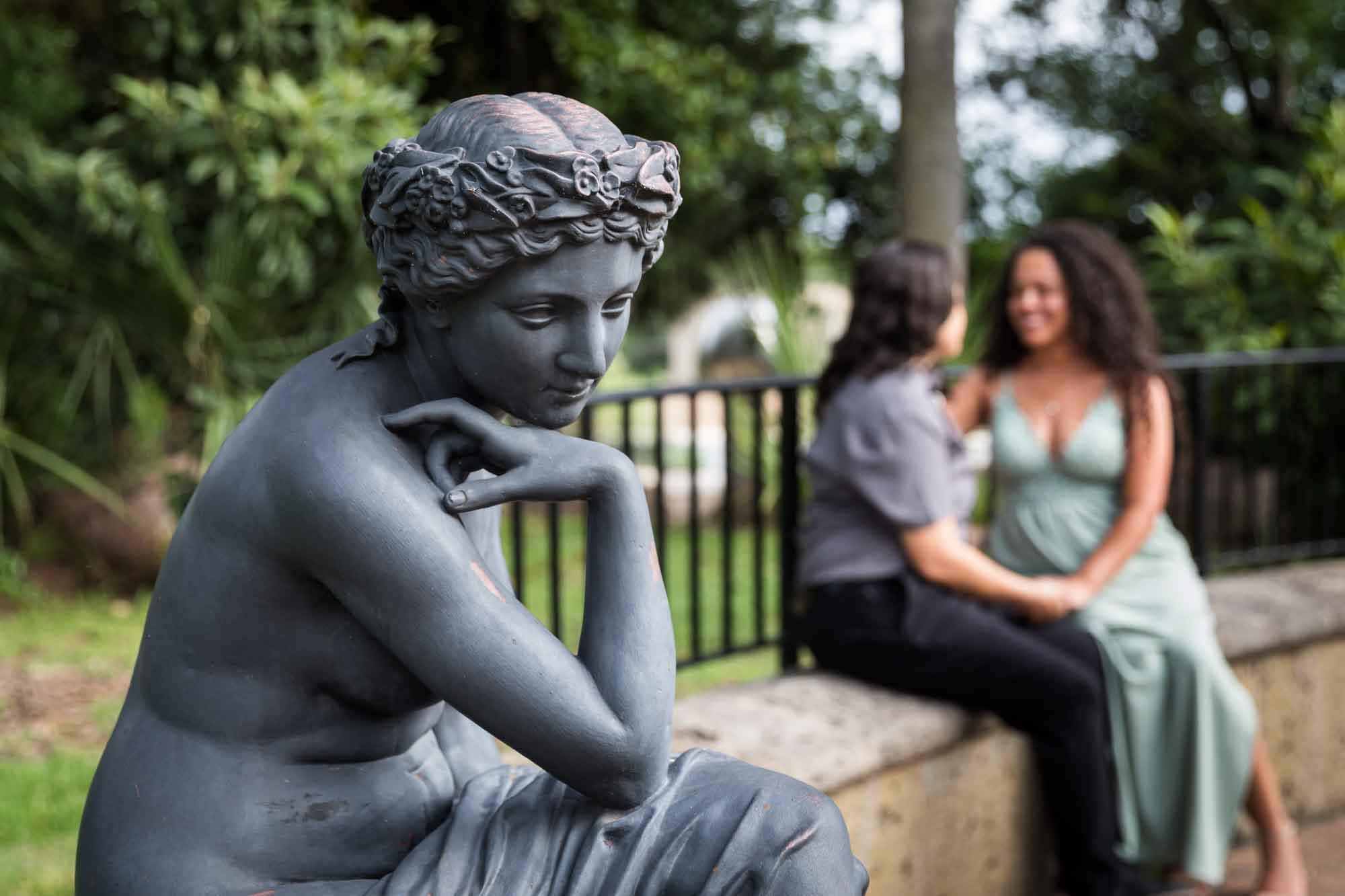 Bronze female sculpture with two women sitting in background for an article about McNay Art Museum proposal tips