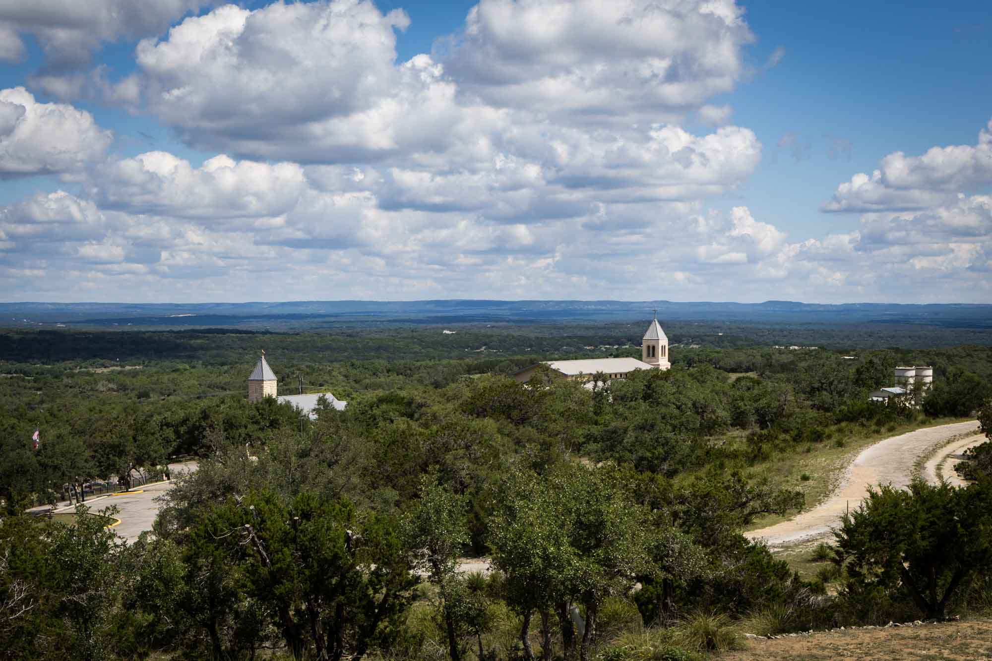View of two churches and trees plus blue sky and clouds above