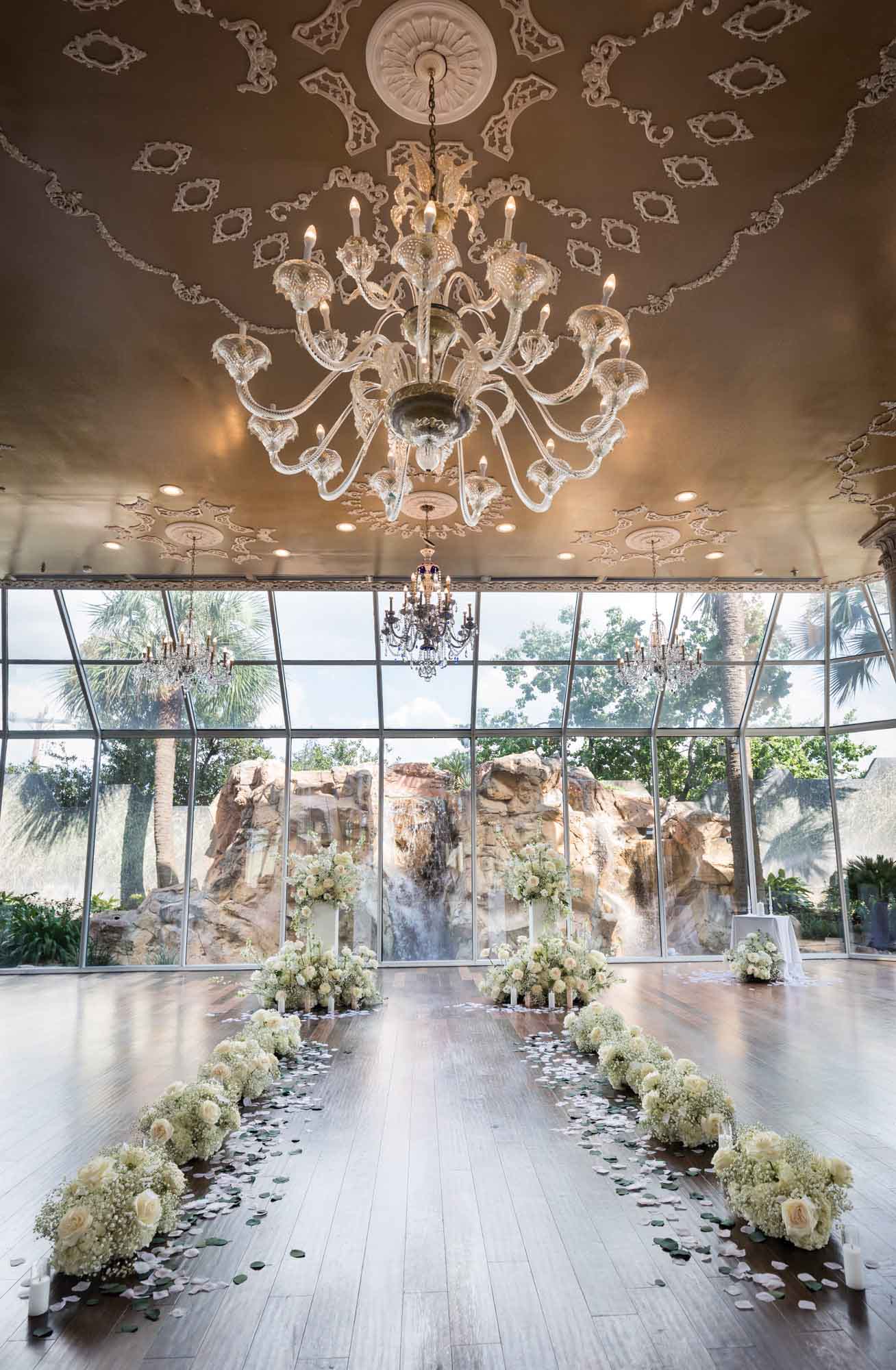 Room with white flowers and large crystal chandelier overhead for an article on affordable wedding venues in San Antonio