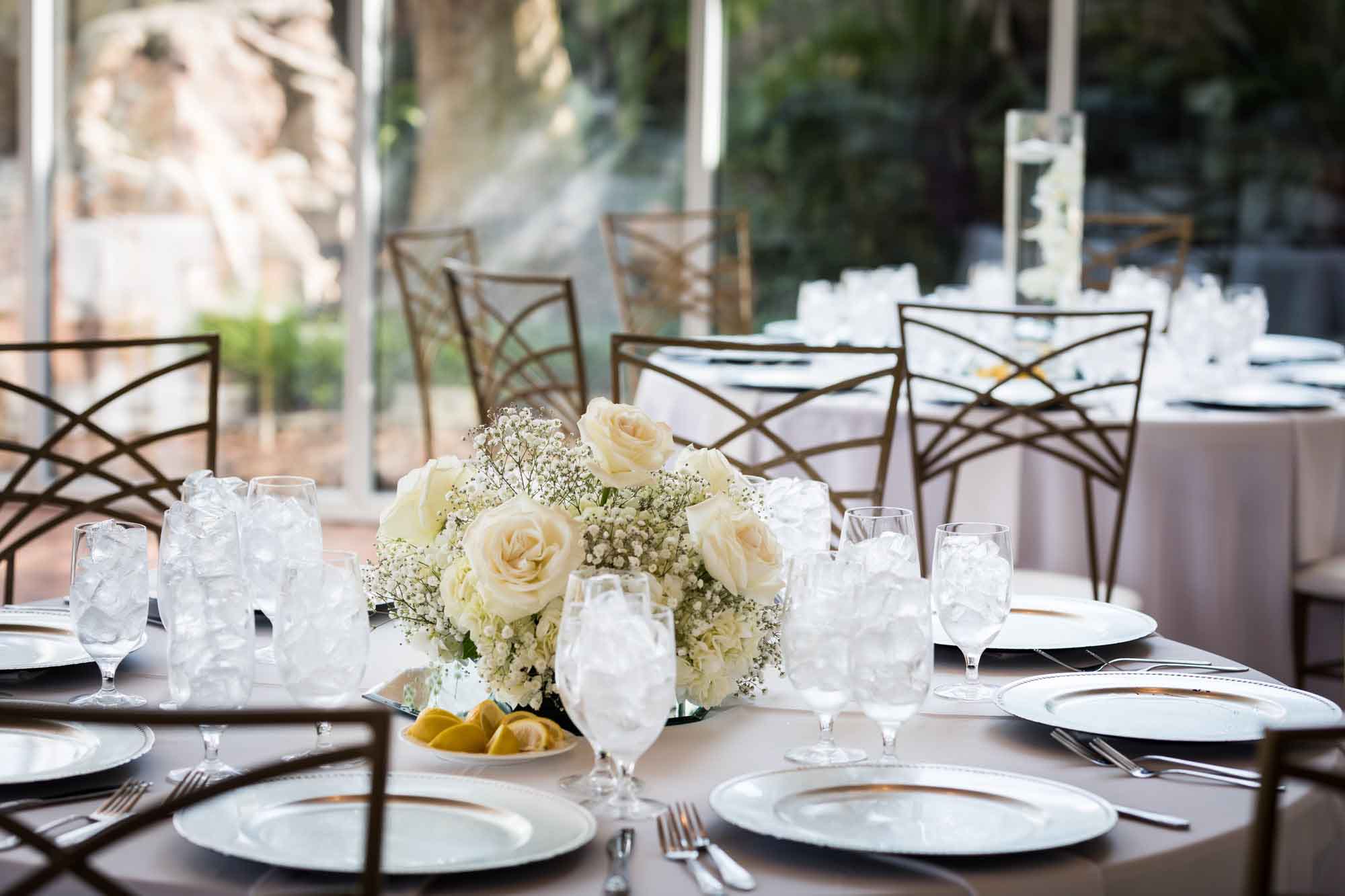 Table set with white flower centerpiece and plates for an article on affordable wedding venues in San Antonio