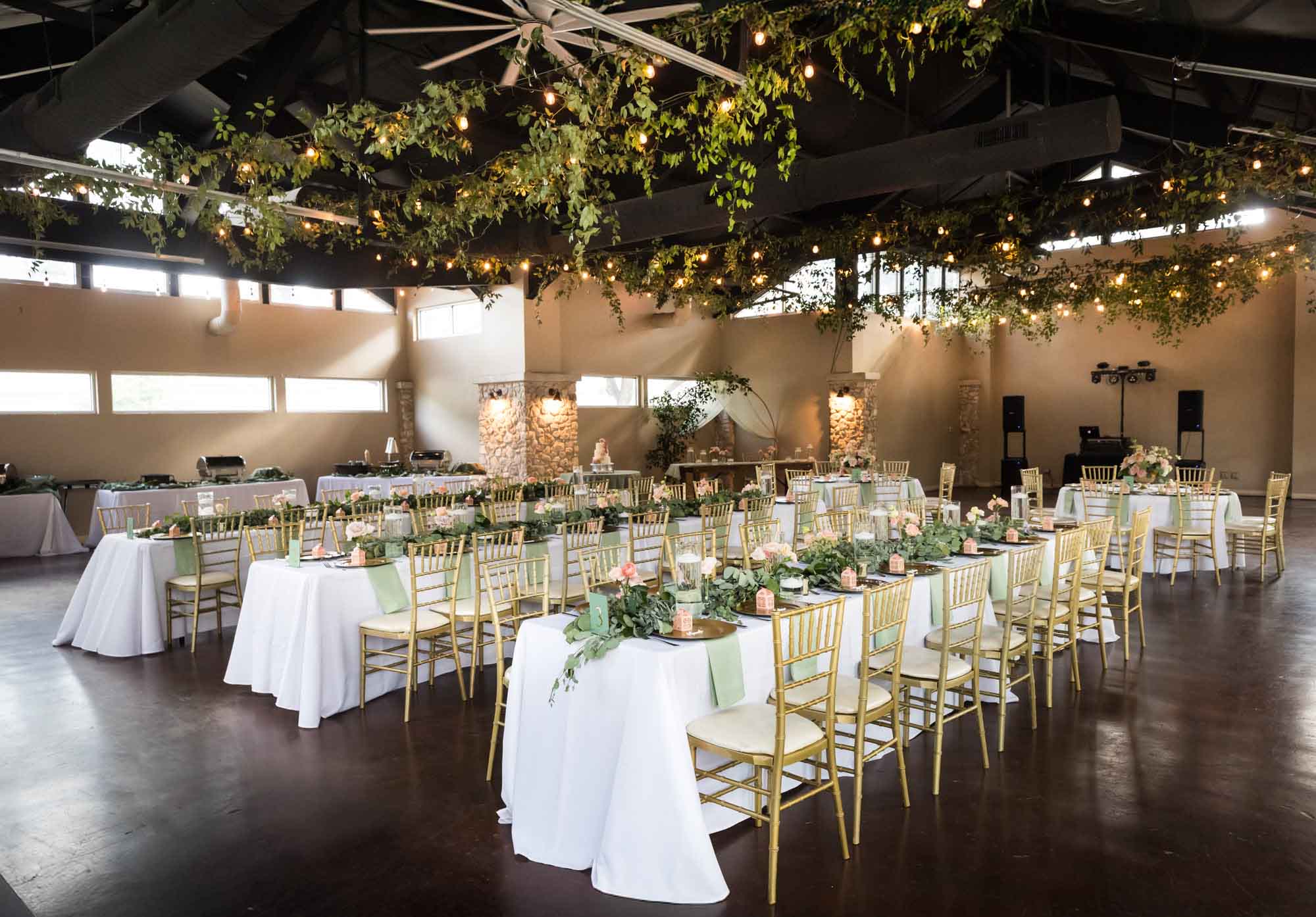 Tables set with greenery and gold chairs at The Veranda for an article on affordable wedding venues in San Antonio