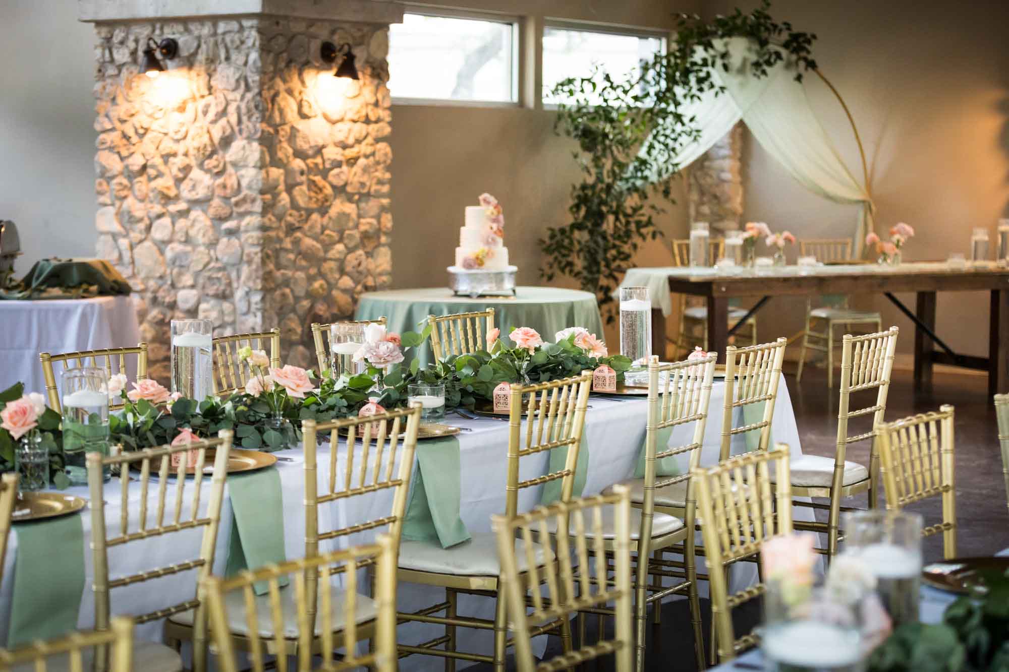 Tables set with greenery and gold chairs at The Veranda for an article on affordable wedding venues in San Antonio