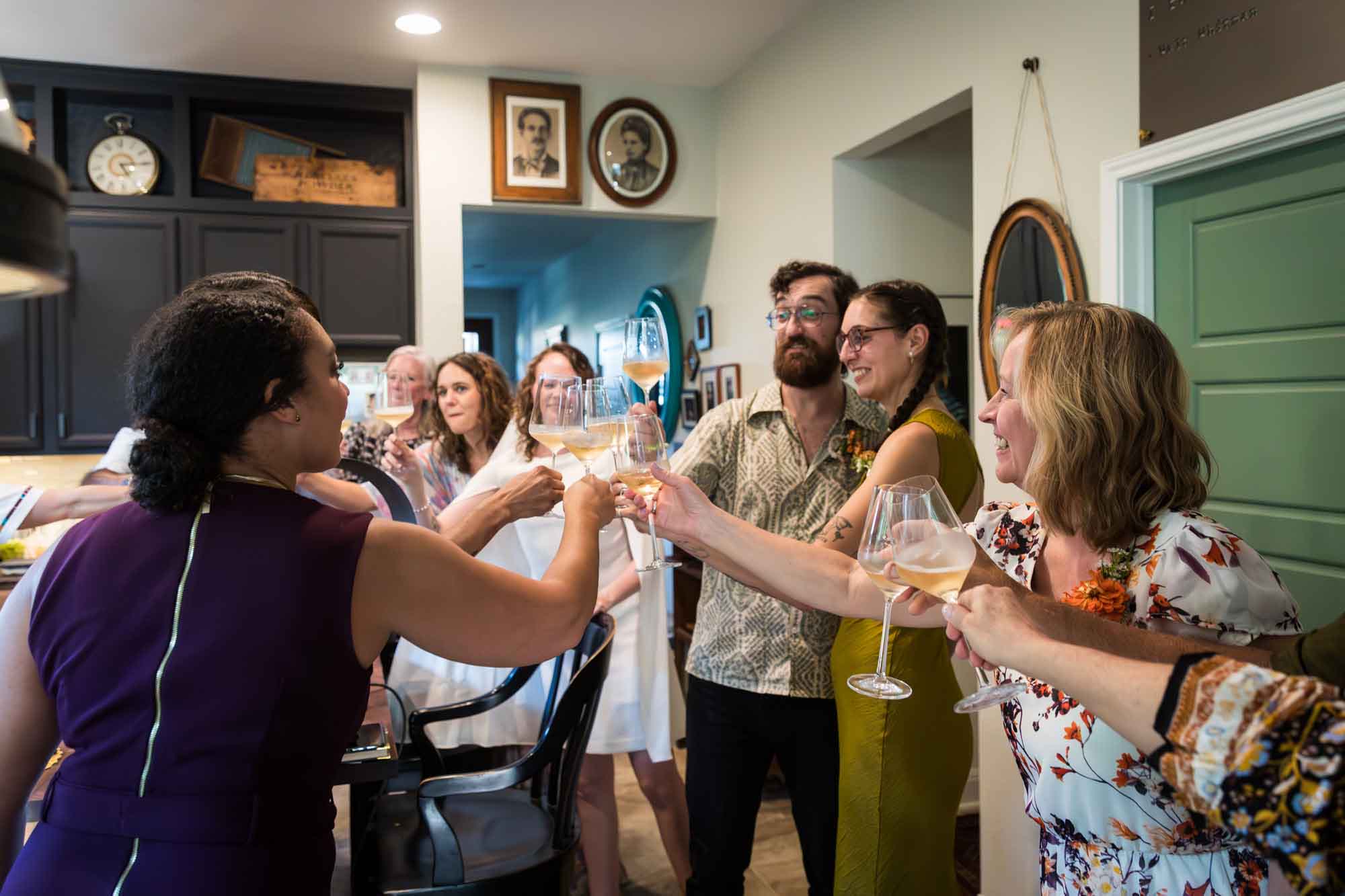 Guests cheering glasses in a kitchen for an article on affordable wedding venues in San Antonio